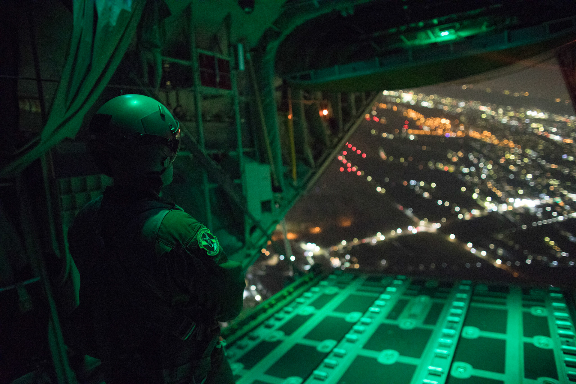 Senior Airman Stephen Clark, 36th Airlift Squadron C-130J loadmaster, observes the ramp while it closes during a training mission over Yokota Air Base, Japan, March 26, 2018. Yokota aircrews regularly conduct night flying operations to ensure they are prepared for a variety of contingencies throughout the Indo-Asia Pacific region. (U.S. Air Force photo by Yasuo Osakabe)