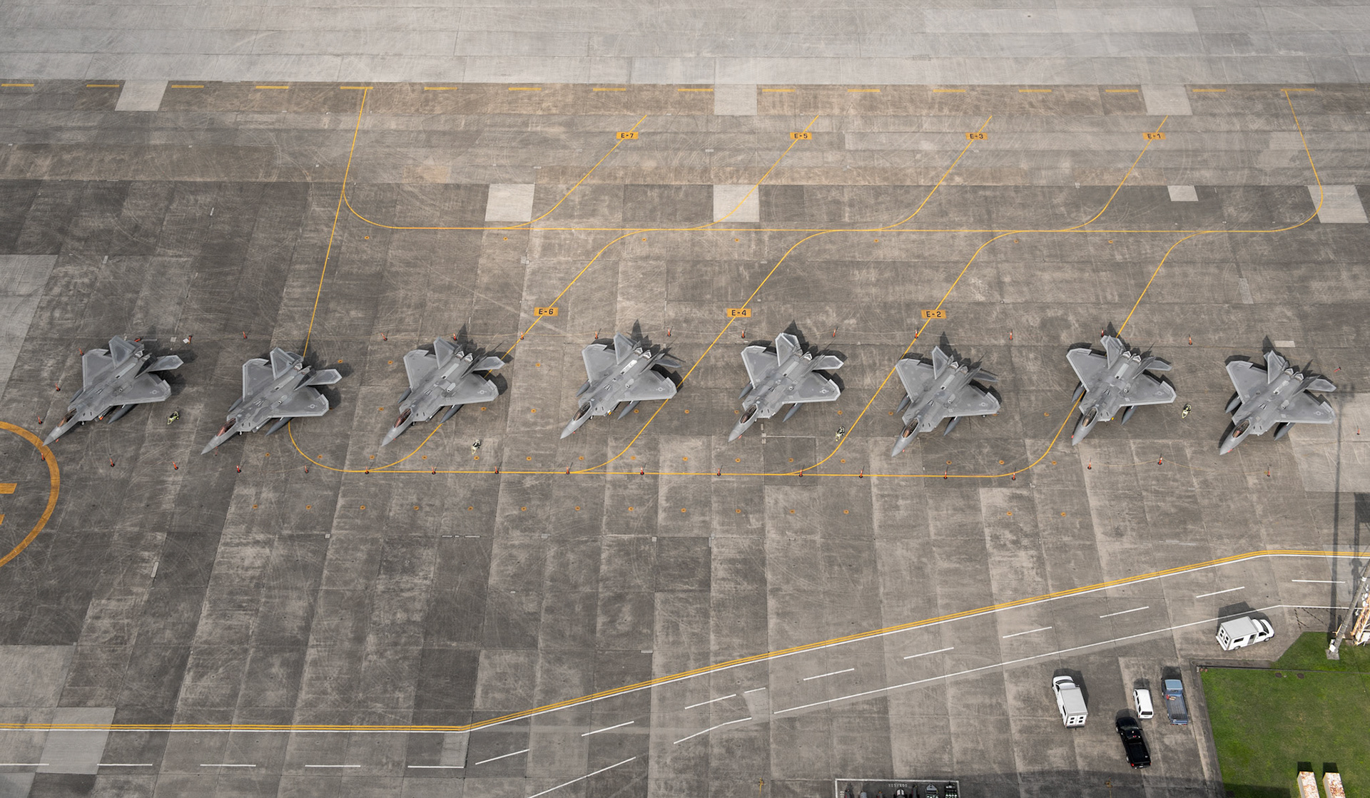 Eight U.S. Air Force F-22 Raptors from Joint Base Elmendorf-Richardson, Alaska, sit on the flightline, July 9, 2018, at Yokota Air Base, Japan. Eight F-22s evacuated from Kadena Air Base, Japan due to Typhoon Maria. The F-22 are deployed under U.S. PACOM’s theater security package (TSP) program, which has been in operation since 2004. (U.S. Air Force photo by Yasuo Osakabe)