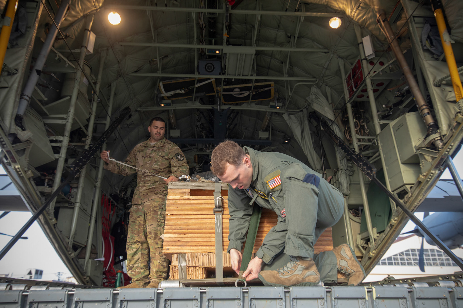 (Right to left) Airman 1st Class Matthew Pfeffer and Tech. Sgt. Brian Gates, 36th Airlift Squadron C-130J loadmasters, secure a low-cost, low-altitude bundle during the Yokota C-130J Rodeo at Yokota Air Base, Japan, March 22, 2019. The flight, airdrop, and offload were a part of the Rodeo competition in which pilots and loadmasters are graded on their ability to execute their skillsets both accurately and expeditiously. (U.S. Air Force photo by Yasuo Osakabe)