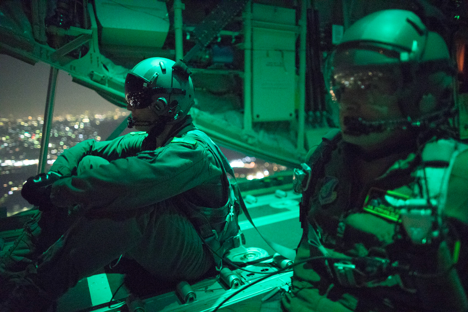 (Right to left) Senior Airman Stephen Clark and Airman 1st Class Matthew Pfeffer, 36th Airlift Squadron C-130J loadmasters, sit on the open ramp of a C-130J Super Hercules flying near Yokota Air Base, Japan, March 26, 2018, before conducting a simulated airdrop over Yokota. Yokota aircrews regularly conduct night flying operations to ensure they are prepared for a variety of contingencies throughout the Indo-Asia Pacific region. (U.S. Air Force photo by Yasuo Osakabe)
