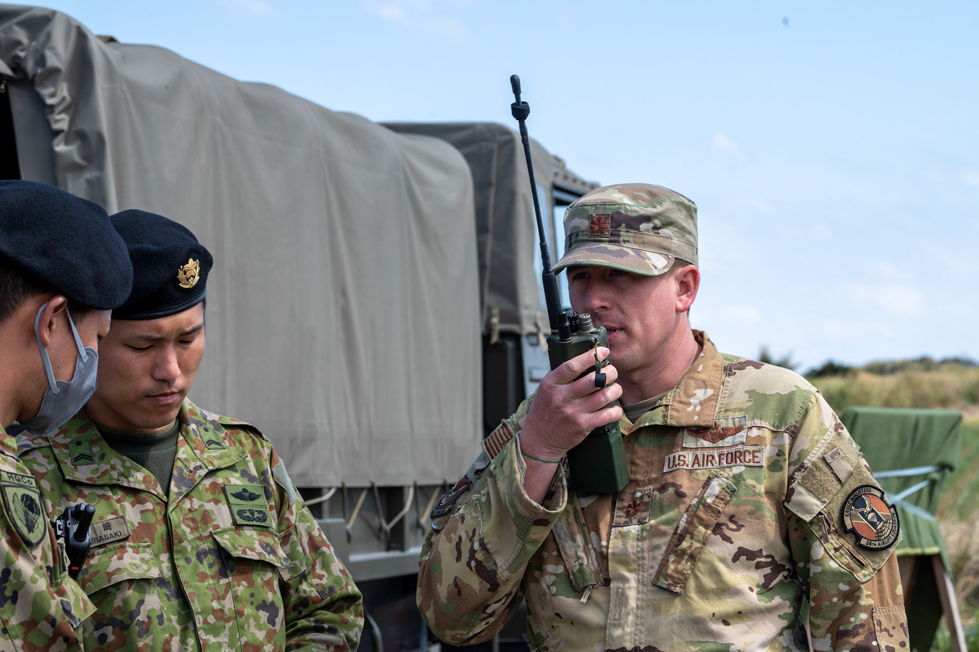 U.S. Air Force Maj. Andrew Morris, 36th Airlift Squadron C-130J Super Hercules pilot, uses a handheld radio to communicate with U.S. Air Force C-130J pilots during Field Training Exercise Iron Fist 23 at Nagamine Drop Zone, Kikaijima Island, Japan, March 3, 2023. During the exercise, the USAF and Japan Self-Defense Forces conducted simulated island seizure airborne operations as the U.S. Marine Corps performed a simultaneous amphibious assault onto the beachhead. (U.S. Air Force photo by Yasuo Osakabe)