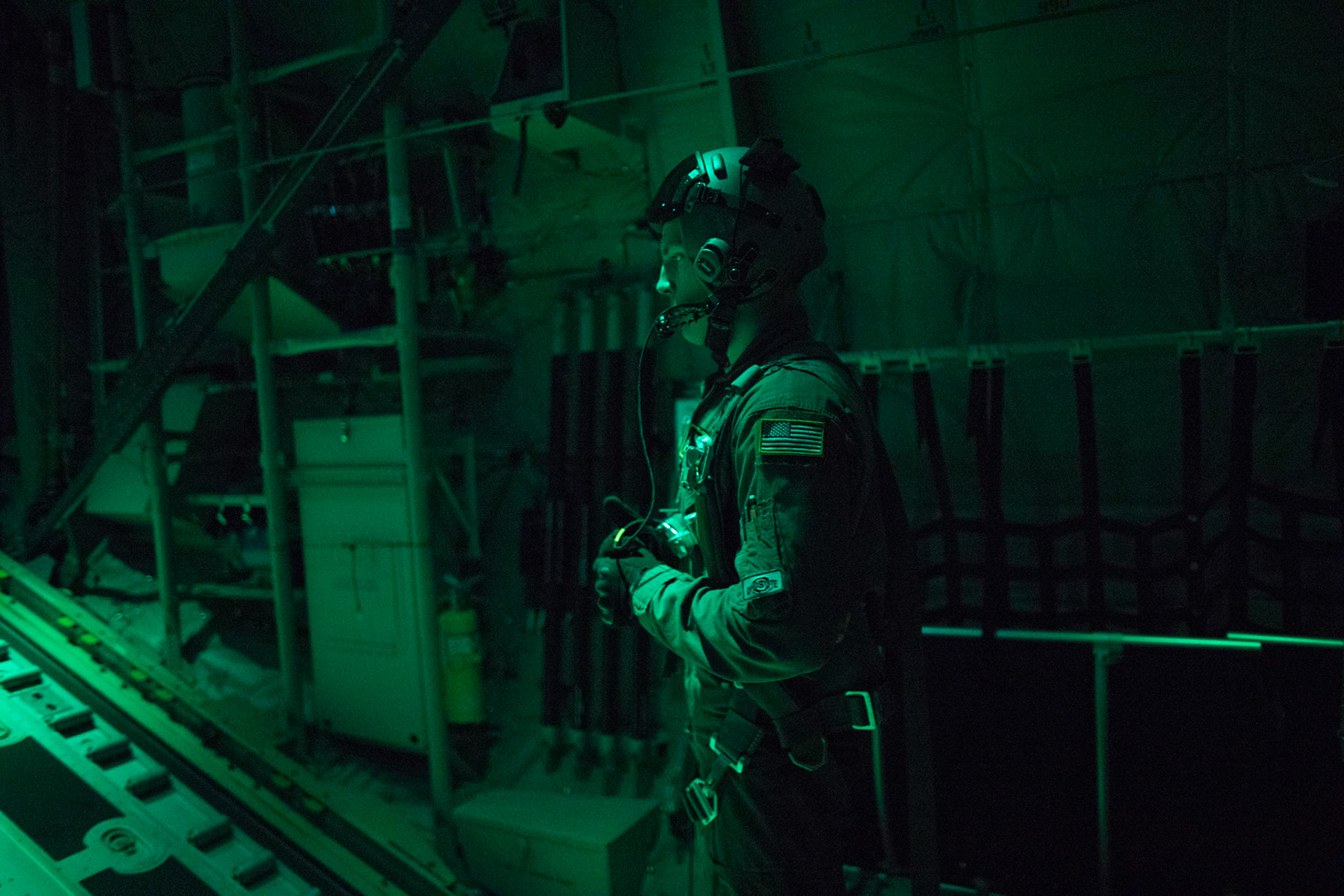 Airman 1st Class Matthew Pfeffer, 36th Airlift Squadron C-130J loadmaster, communicates with aircrew during a training mission over the Kanto Plain, Japan, March 26, 2018. Yokota aircrews regularly conduct night flying operations to ensure they are prepared for a variety of contingencies throughout the Indo-Asia Pacific region. (U.S. Air Force photo by Yasuo Osakabe)
