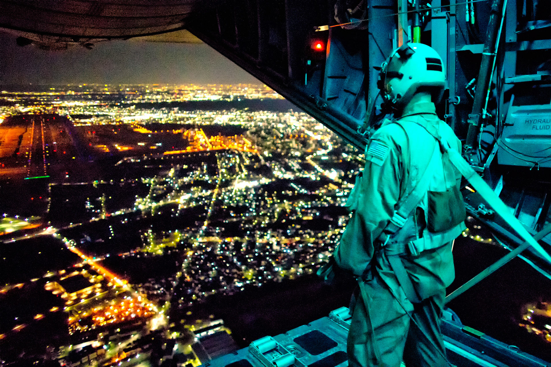 Staff Sgt. Nickolas Alarcon, 36th Airlift Squadron loadmaster, observes a drop zone from the rear of a C-130 Hercules after deploying a light payload above Yokota Air Base, Japan, Feb. 21, 2013. The C-130 aircrews demonstrated their airlift capabilities during a readiness week. (U.S. Air Force photo by Osakabe Yasuo)