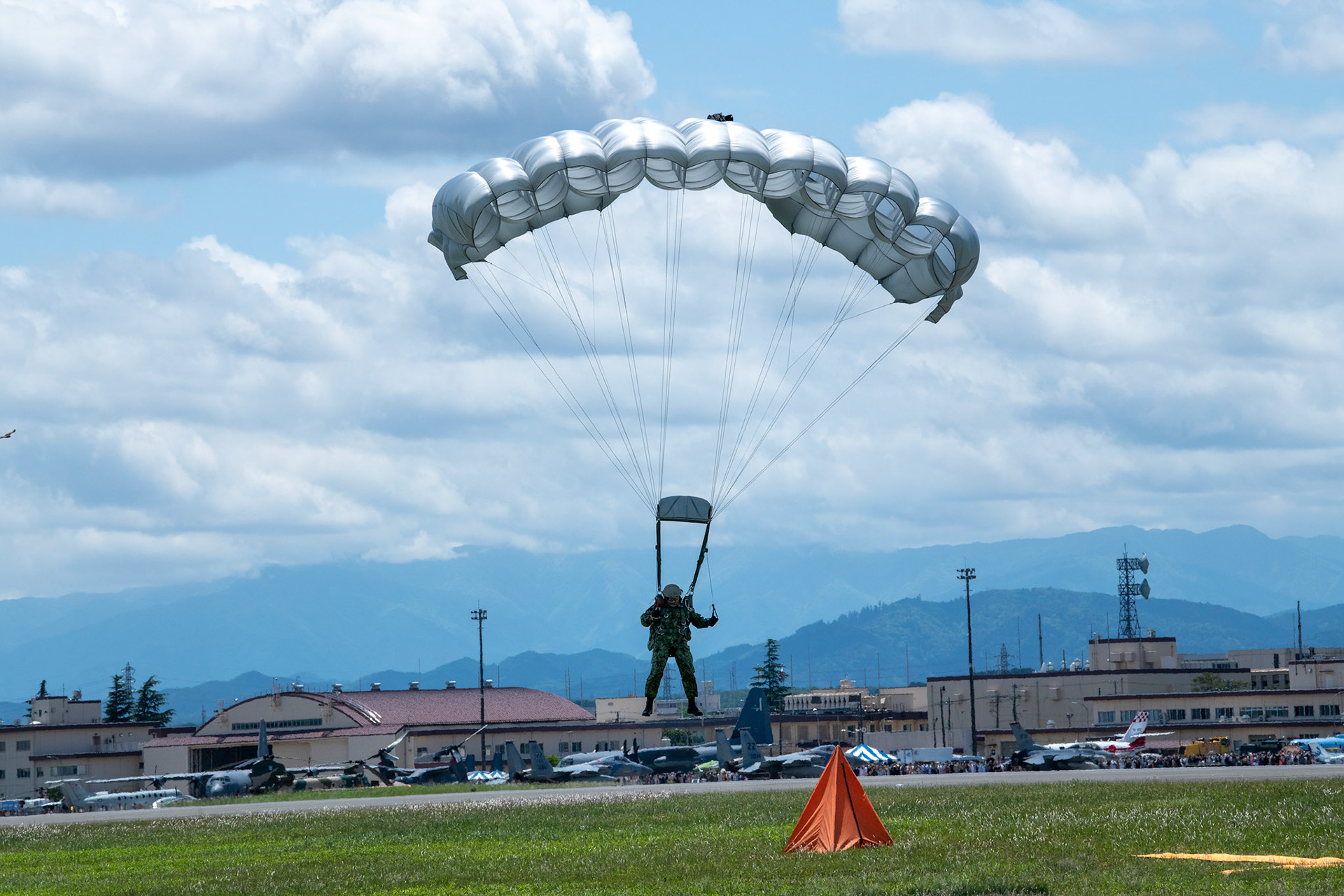 A Japan Ground Self-Defense Force paratrooper assigned to the 1st Airborne brigade descends from a USAF C-130J Super Hercules assigned to the 36th Airlift Squadron during the Japanese-American Friendship Festival at Yokota Air Base, Japan, May 22, 2022. A six member team comprised of U.S. Air Force and JGSDF paratroopers, conducted a military free fall demonstration to show their capabilities during the festival. During the two-day festival, more than 110,000 attendees came to Yokota to experience the event. The festival is aimed at increasing bilateral relationships between U.S. and Japanese communities and allows people to see U.S. and Japanese military capabilities first-hand. (U.S. Air Force photo by Yasuo Osakabe)