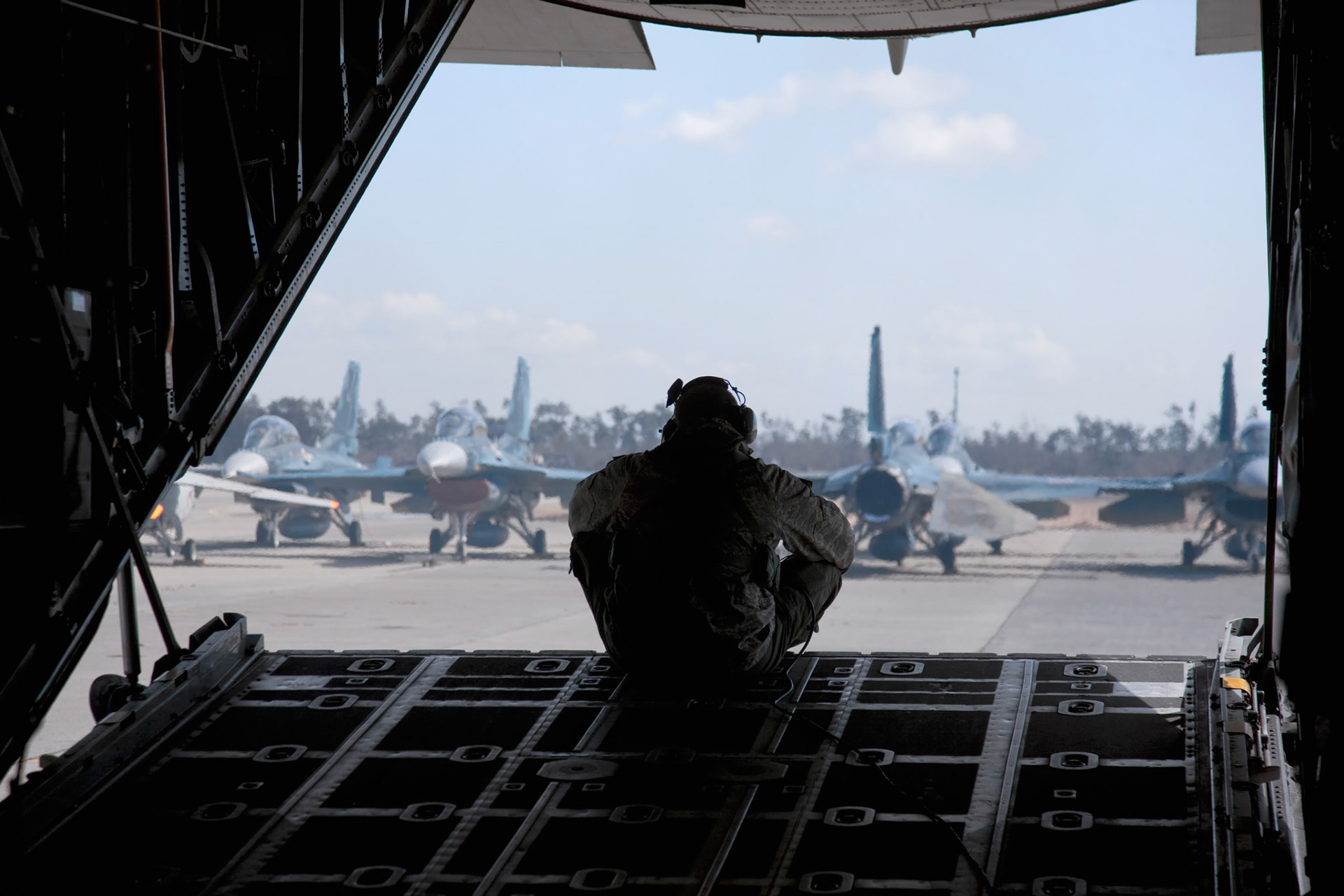 MATSUSHIMA AIR FIELD, Japan -- Senior Airman Ramon Mortensen, a 17th Special Operations Squadron loadmaster, looks at damaged F-2 fighters after landing here March 18 to drop of relief supplies. The aircraft were damaged after an 8.9 magnitude earthquake and following tsunami that rocked Northeastern Japan March 11.