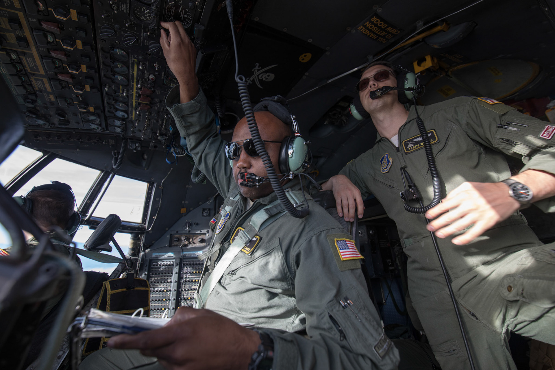 Tech. Sgt. Joshua Pittman, left, 36th Airlift Squadron C-130H flight engineer, inputs a data during a tactical training sortie over Izu Peninsula, Japan, Oct. 5, 2017. The flight engineer is primarily concerned with the operation and monitoring of all aircraft systems. (U.S. Air Force photo by Yasuo Osakabe)