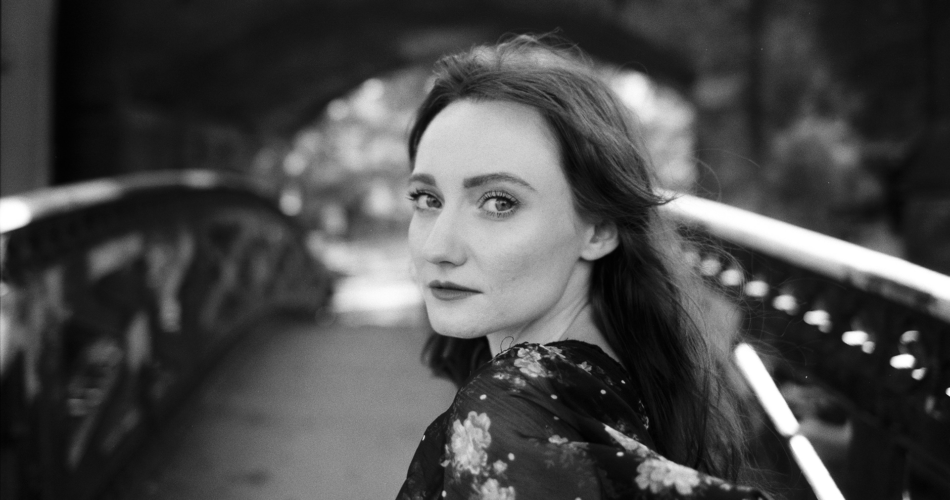 woman and model looking back whilst crossing a footbridge