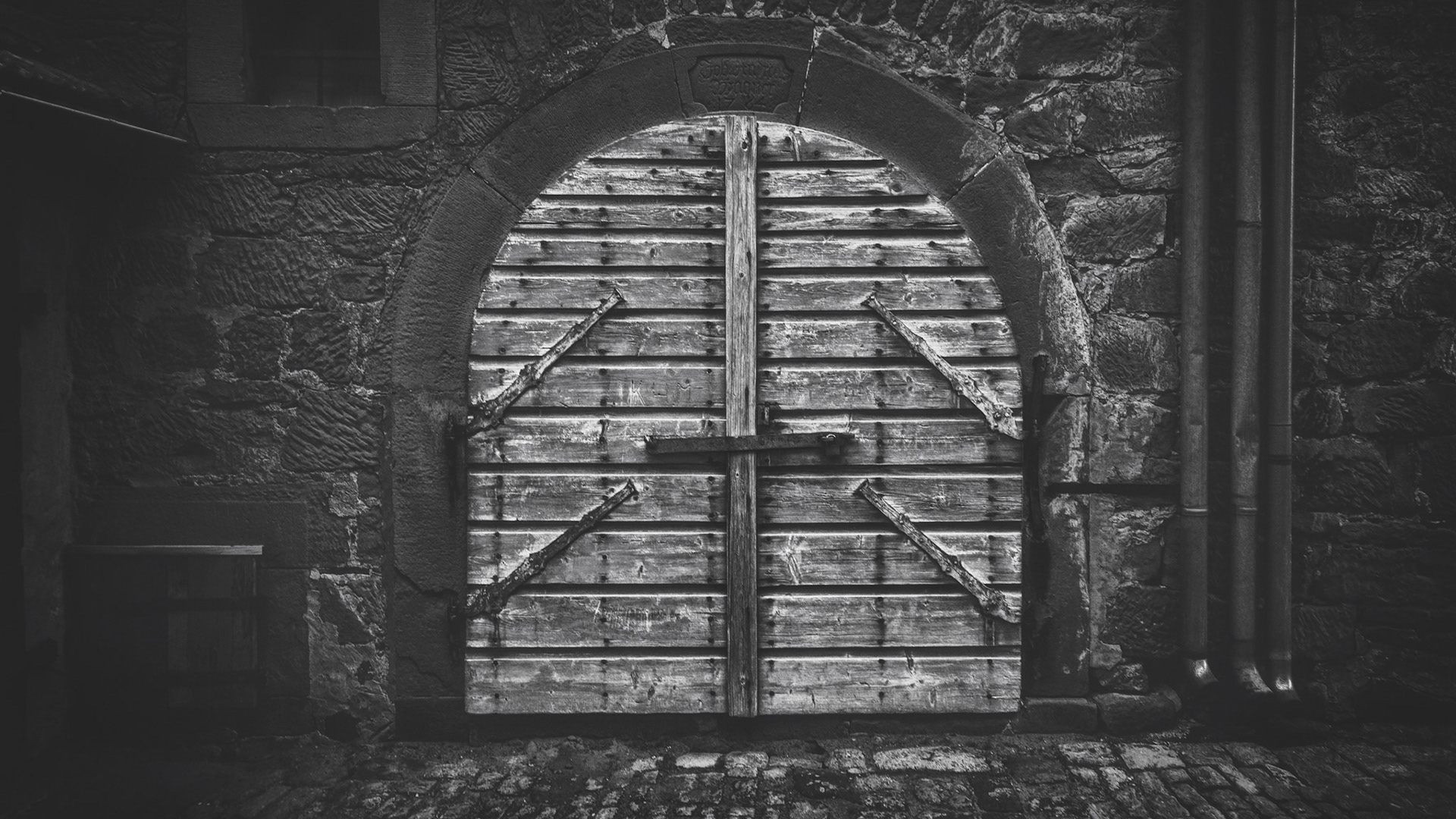 I've found this closed old and secret door in the backyard of a lonely farmhouse. It was closed. What may be behind it?