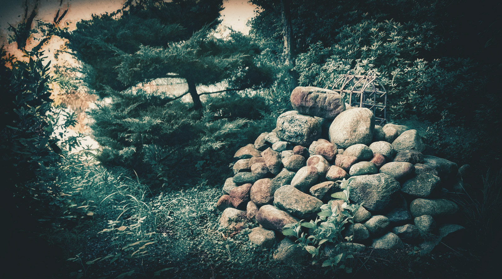 At a lonely lake in the forest I found this heap of stones. I asked the owner of this property what's all about those stones. He told me, that this is a stone grave. I didn't ask who or what is interred there ... but this is really spooky.
