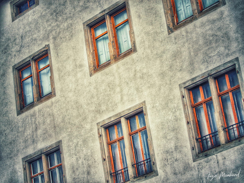 An old facade with different windows.