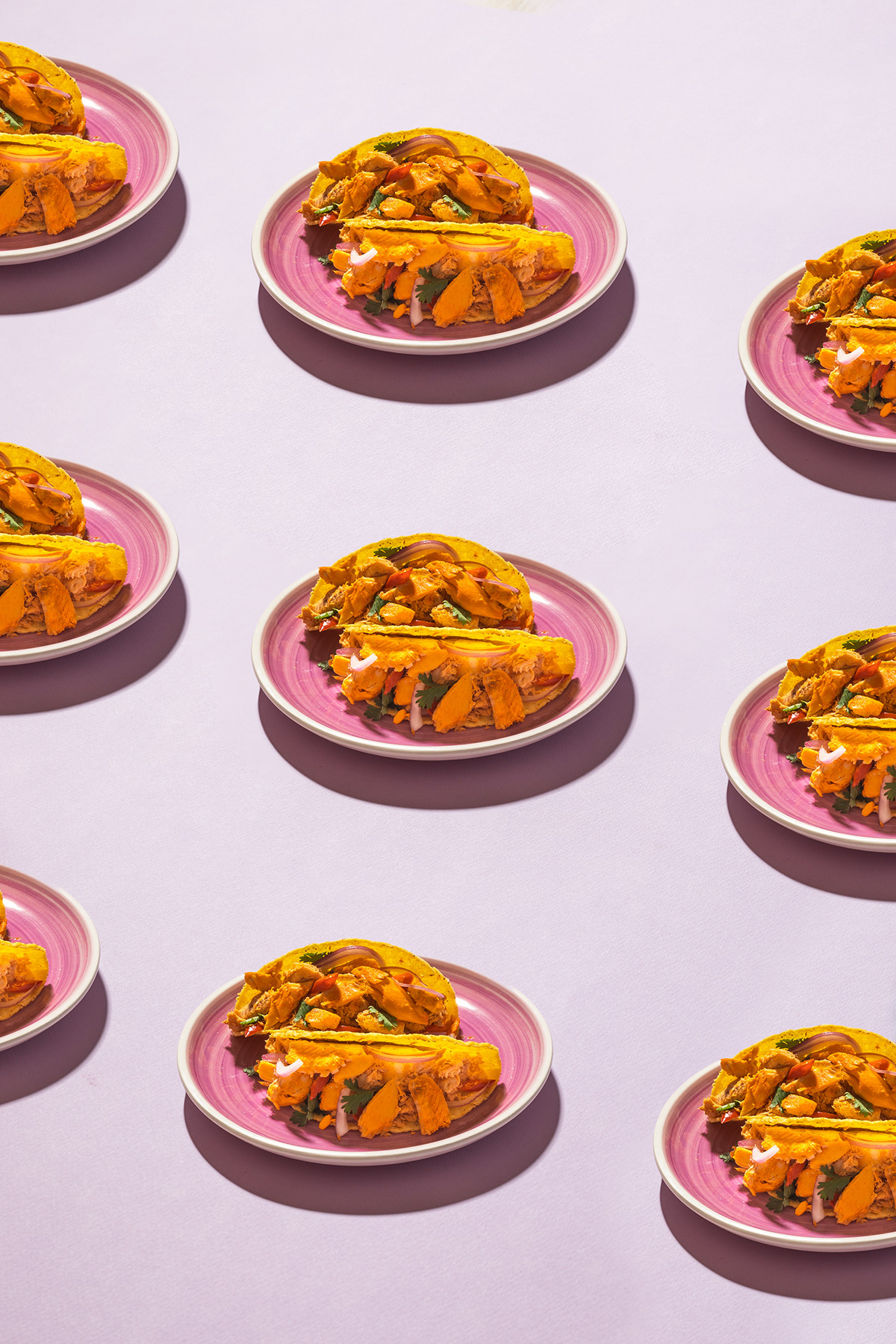 Pattern of plated sandwiches arranged on a lavender background