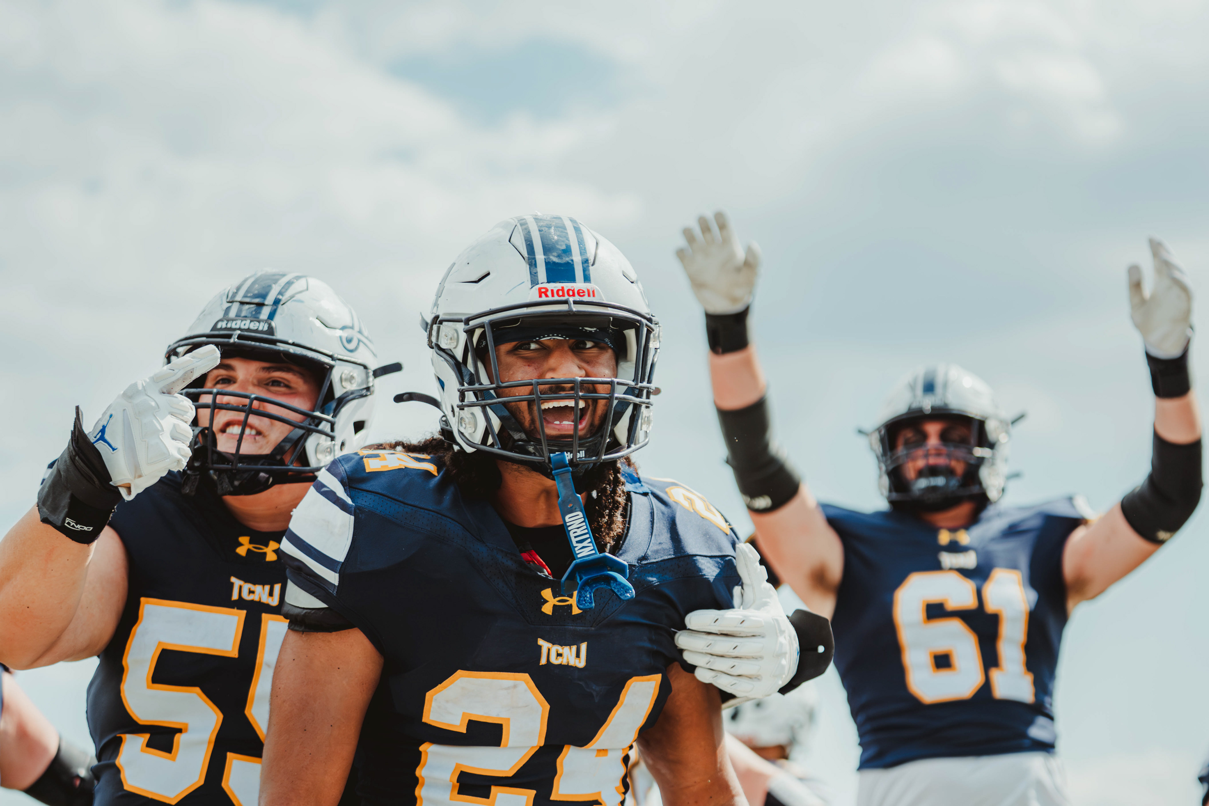 The College of New Jersey running back Jordan Morrell (24), offensive linemen Tyler Addonisio (55) and Tommy Jurcsek (61) celebrate a touchdown against Wilkes University at Lions Stadium in Ewing, N.J., on Sep. 13, 2025.