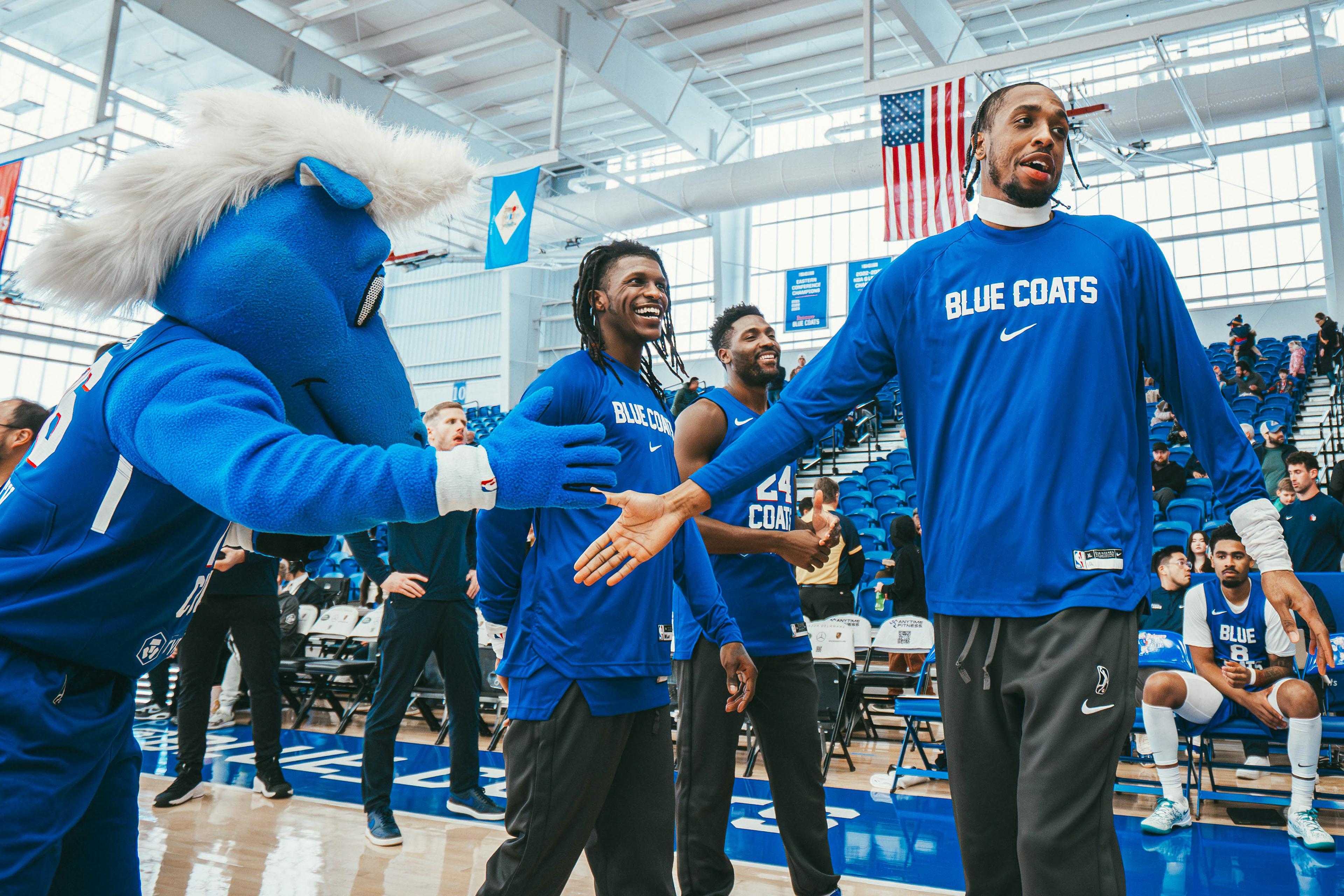 Delaware Blue Coats forward DeAndre Williams (12) high-fives Coaty during player introductions before a game against the Birmingham Squadron at Chase Fieldhouse on Jan. 4, 2026.