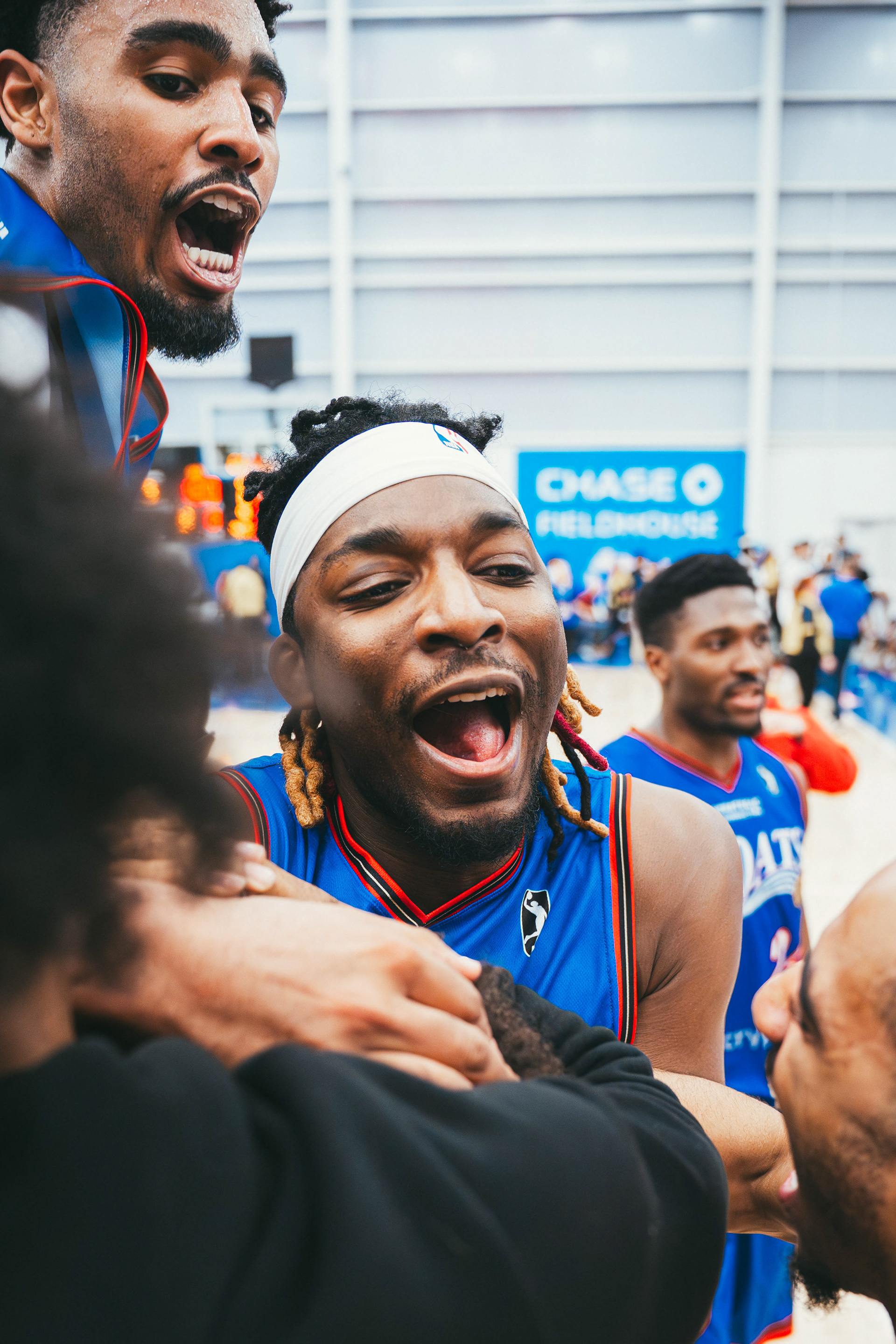 Delaware Blue Coats center Drew Cisse (77) and guards Saint Thomas (8) and Kellen Tynes celebrate after a 122–120 overtime victory against the Capital City Go-Go at Chase Fieldhouse on March 28, 2026.