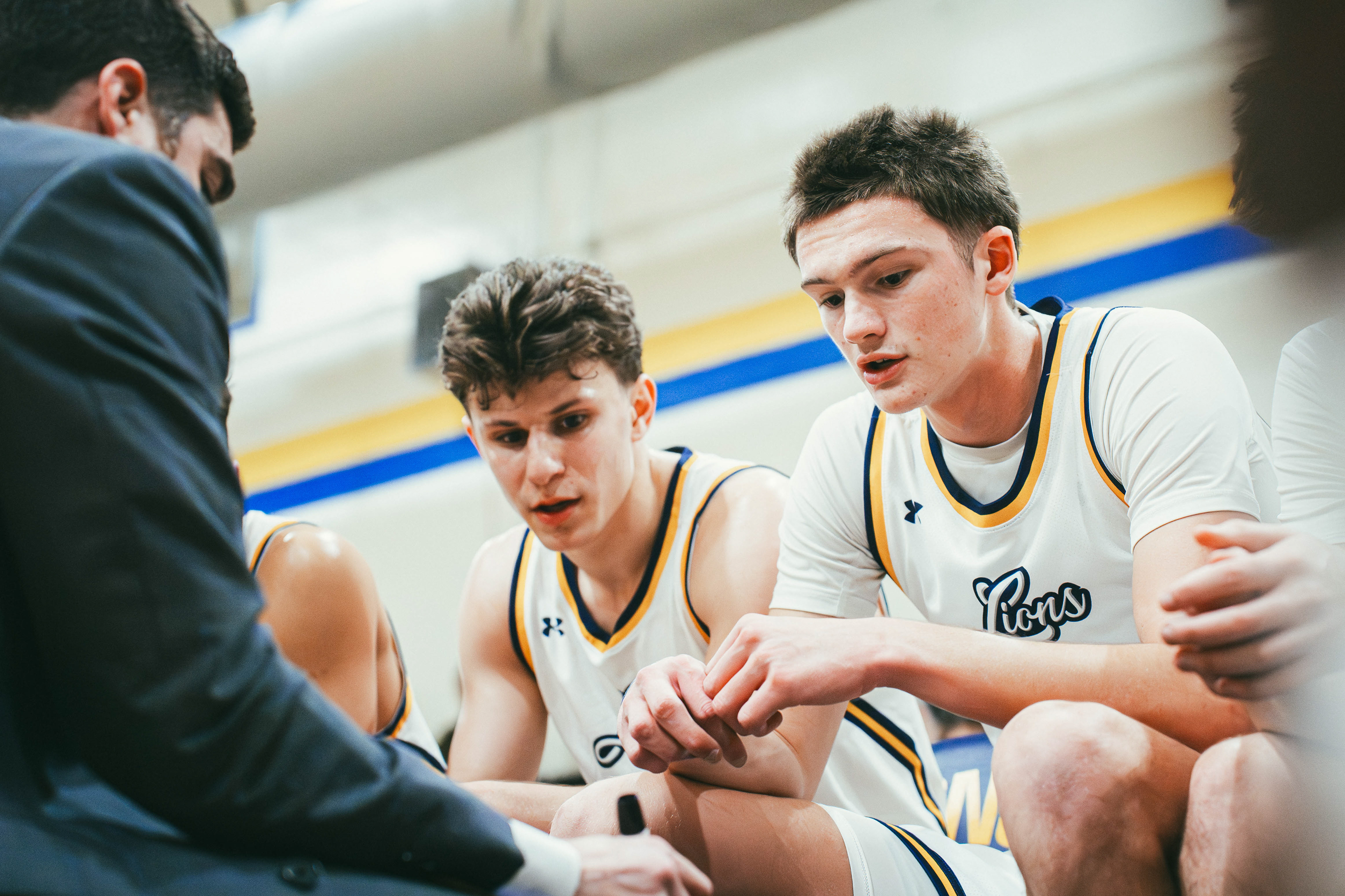The College of New Jersey Nick Koch (2) and Daniel Yarus (10) listen to head coach Evan Elberg during timeout in a game against New Jersey City University at Packer Hall in Ewing, N.J., on Jan. 17, 2026.