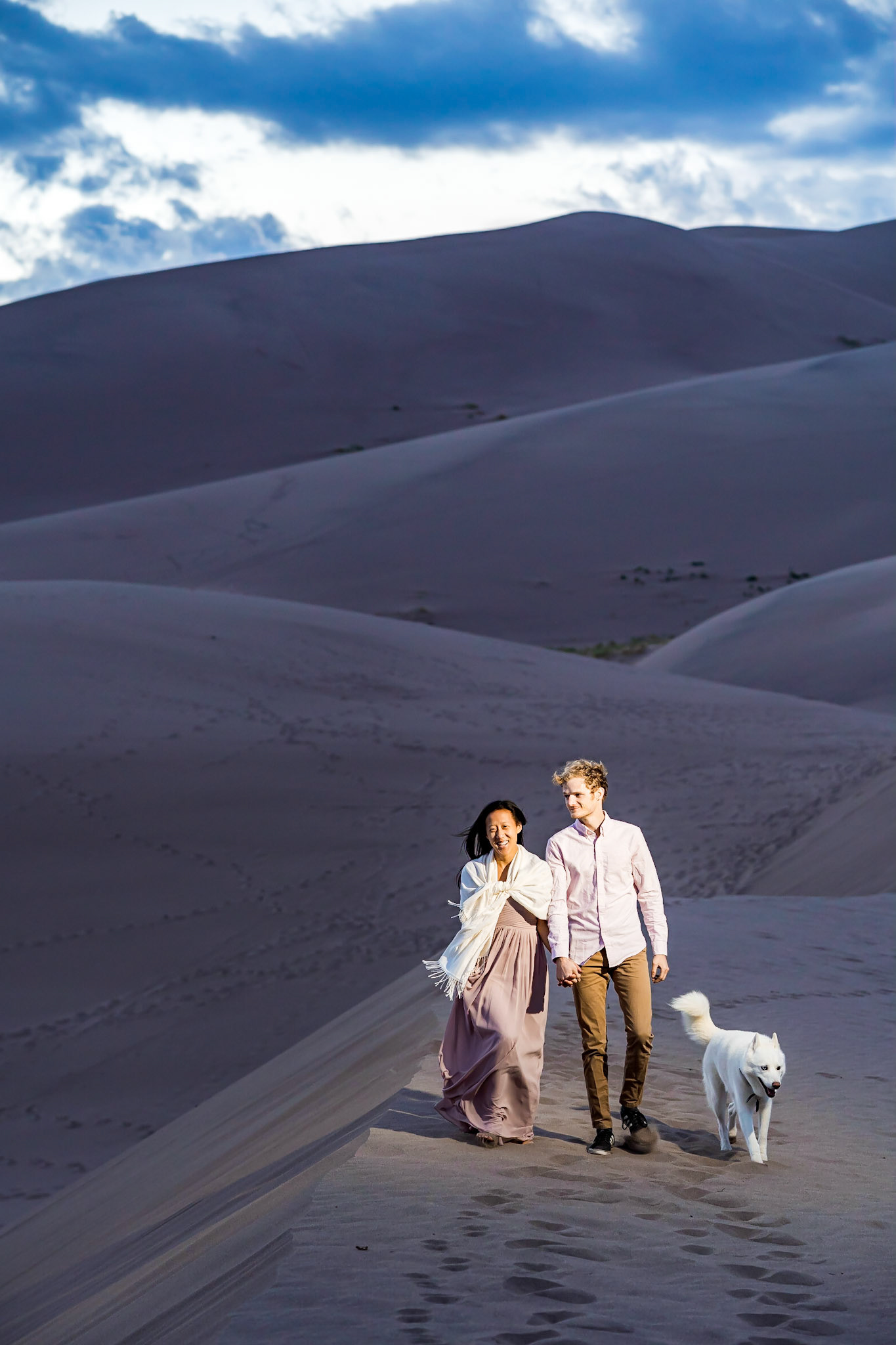 Adventure engagement session at the Great Sand Dunes in Colorado. Camping trip with husky dog. Sunrise and Sunset photos on the Dunes.
