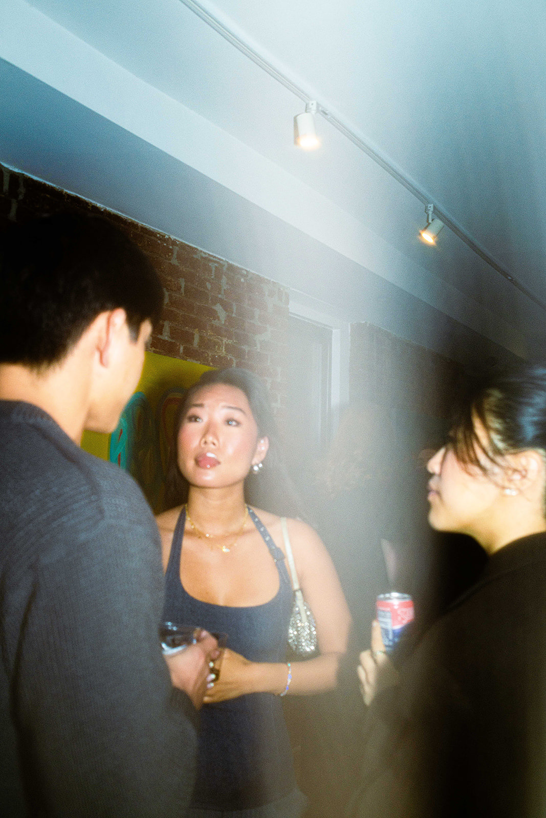 People talking in NYC art gallery,  photographed on film by photographer Lana Dubkova