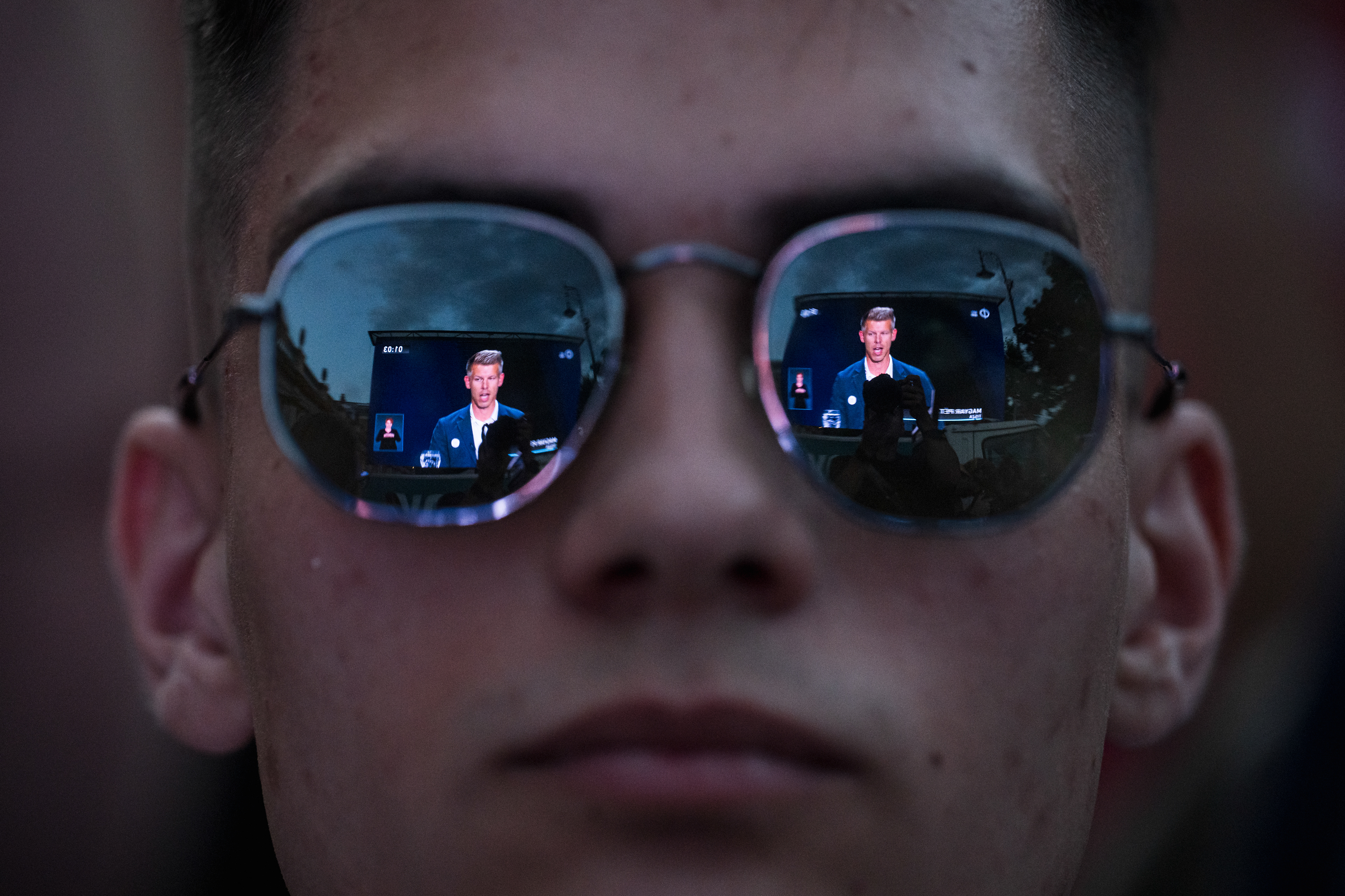 A man watches the EU election candidates debate from a screen in front of the Várkert Bazár in Budapest.