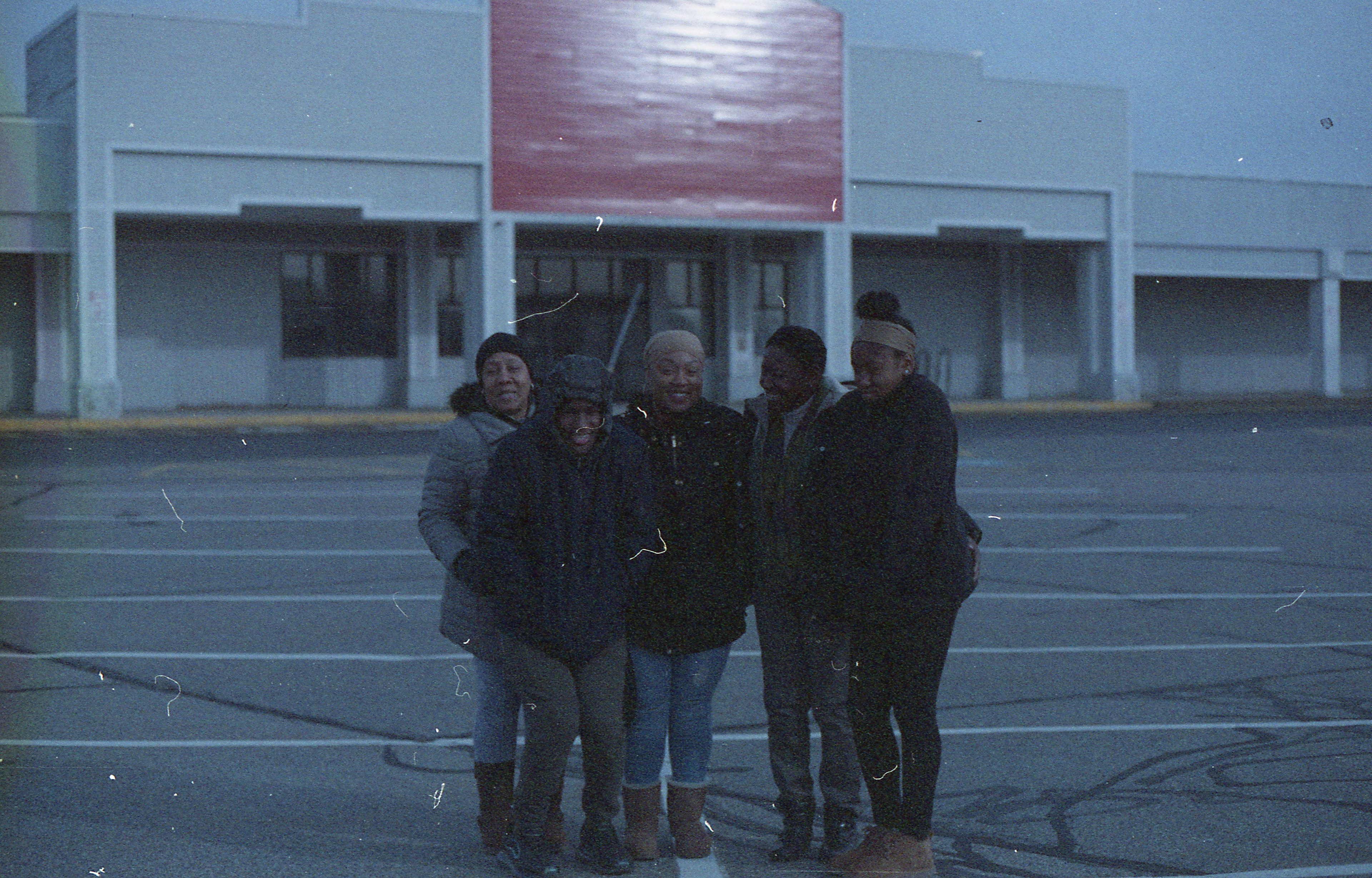 A family portrait takes place outside an empty storefront.