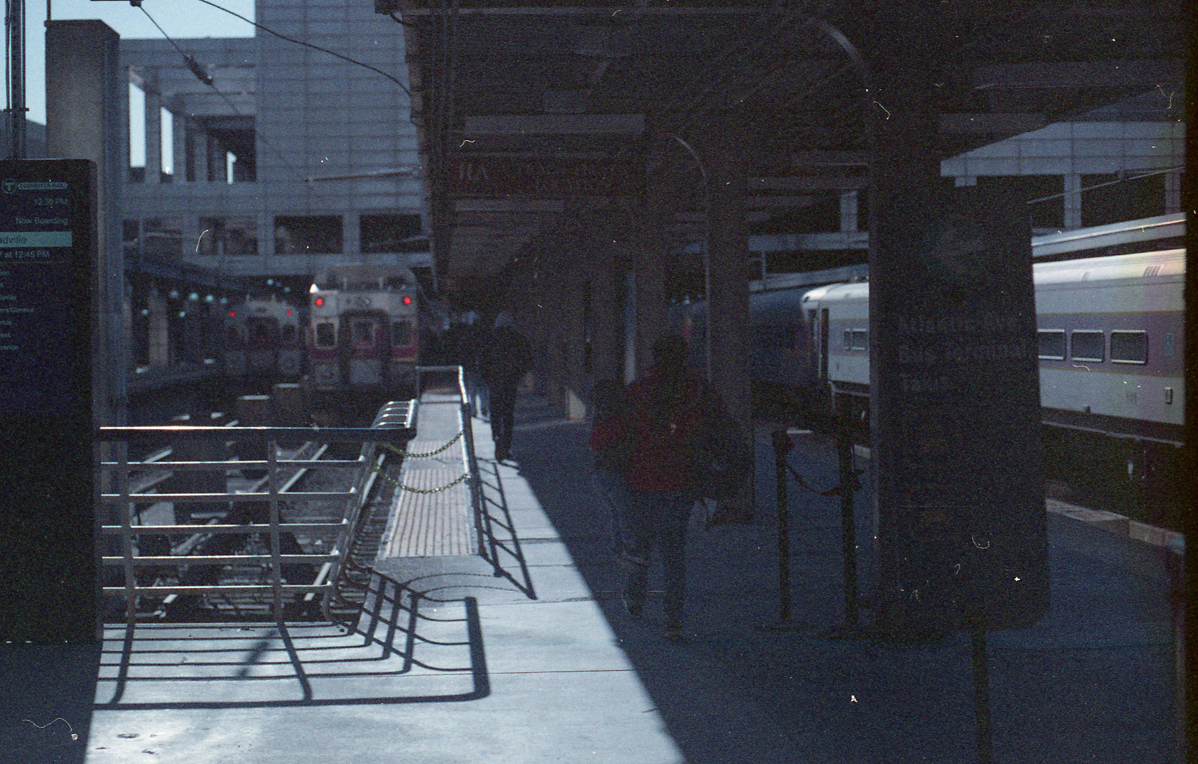 A parent tows their child in one arm off to the commuter rail.
