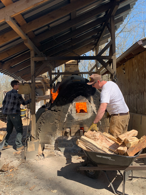 Trevor Youngberg (white) stoking the Beluga-Gama kiln