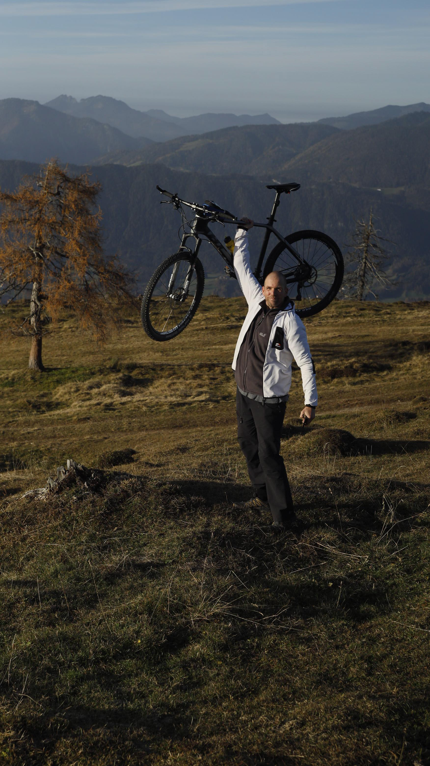 Johann Erhard mit Fahrrad am Grassbergjoch, im Hintergrund Brandenberger Alpen