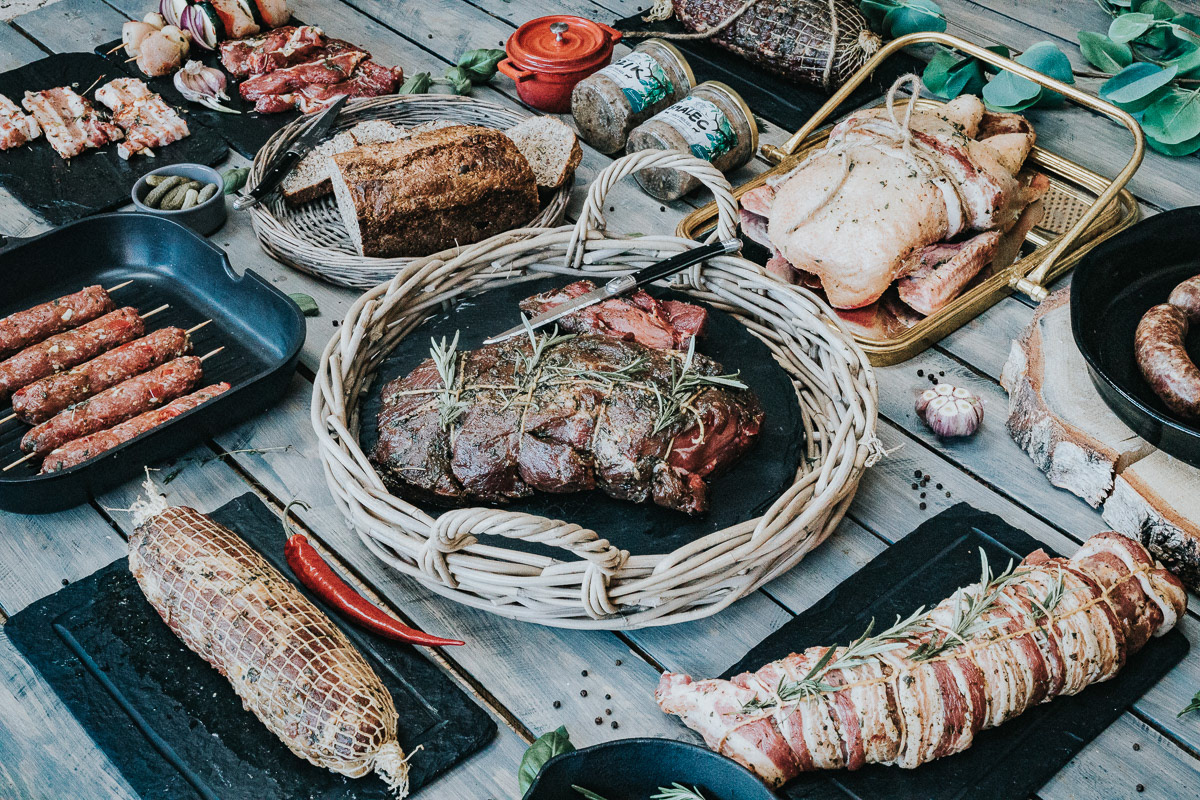 pyszne mięsa na grill ułożone równo na stole drewnianym do sesji zdjęciowej