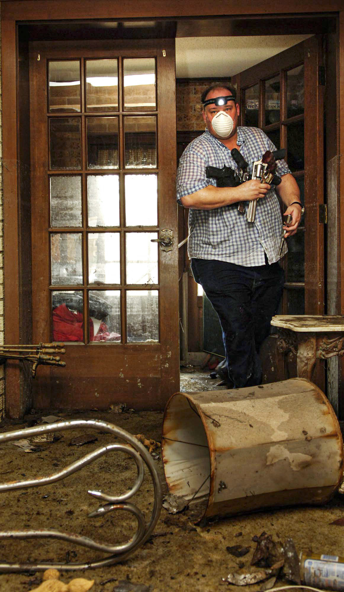 Ray Bianchani leaves his destroyed home after removing his weapons from a locked safe in St. Bernard Parish.