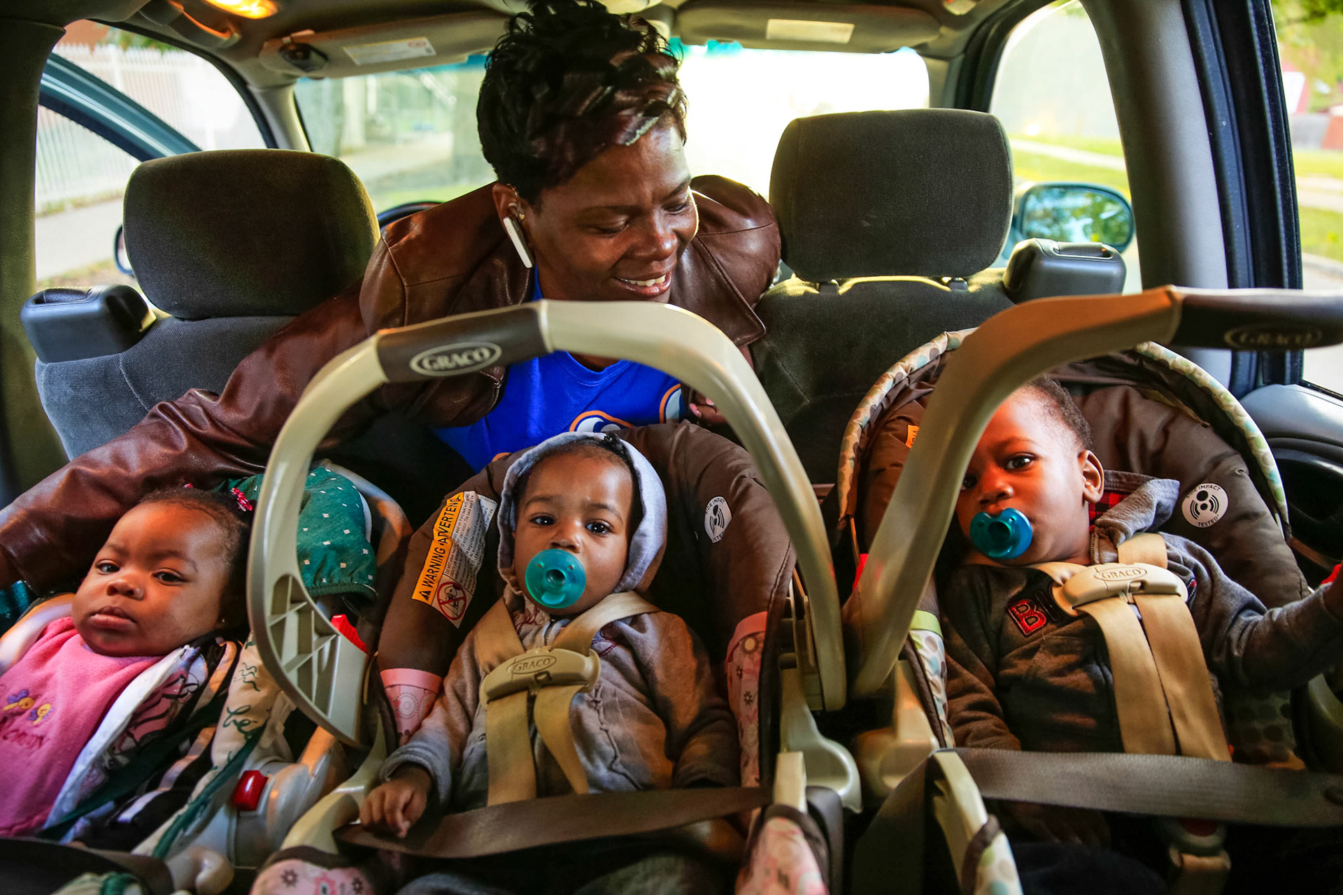 Sandra Brown, 48, looks over three young clients she's collecting to take to her business,”Agape Love Home Day Care.”