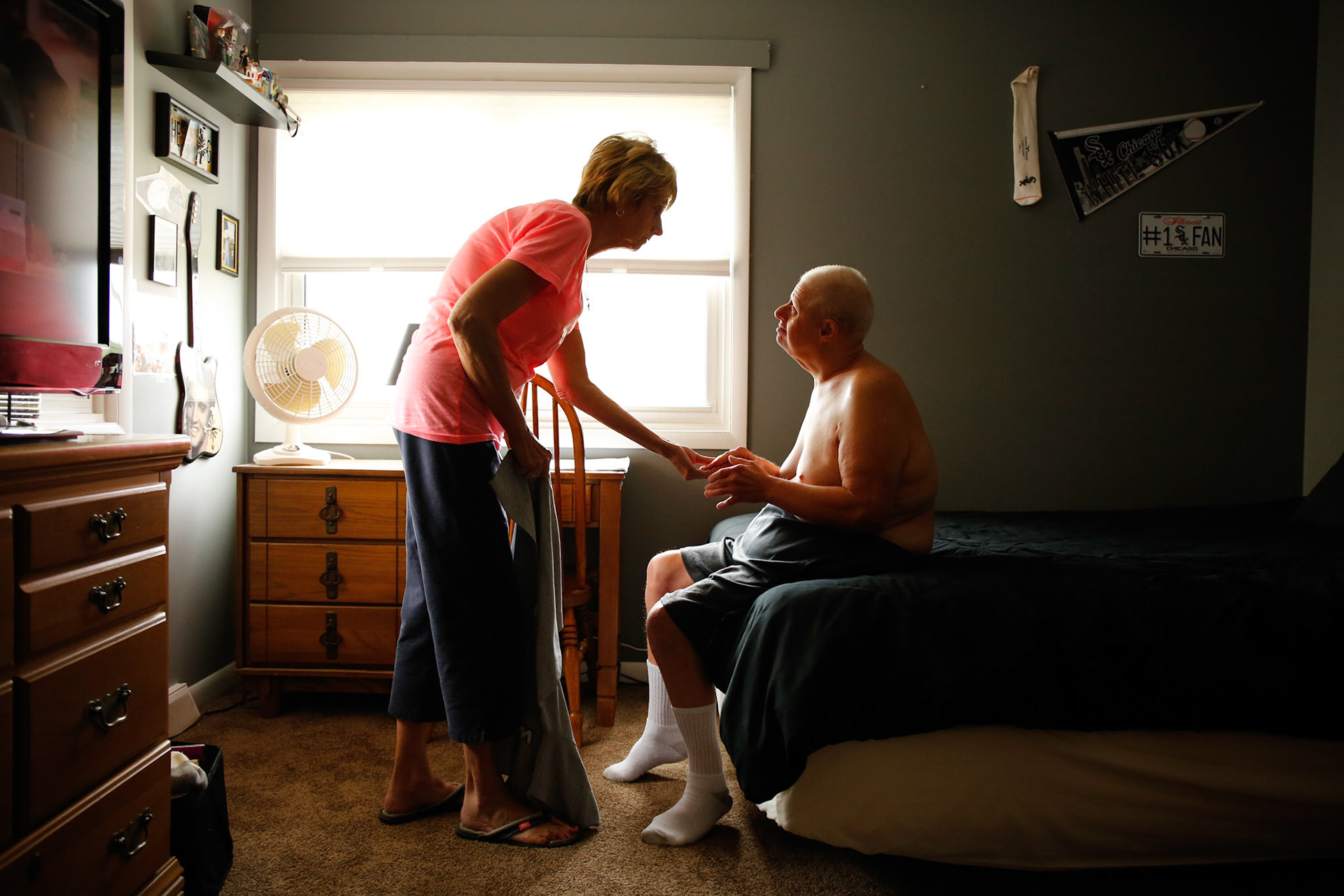 Marilyn Long, left, of Elk Grove Village, Illinois, helps her disabled brother, Jeff Malanoski, 57, get dressed. (ChicagoTribune)