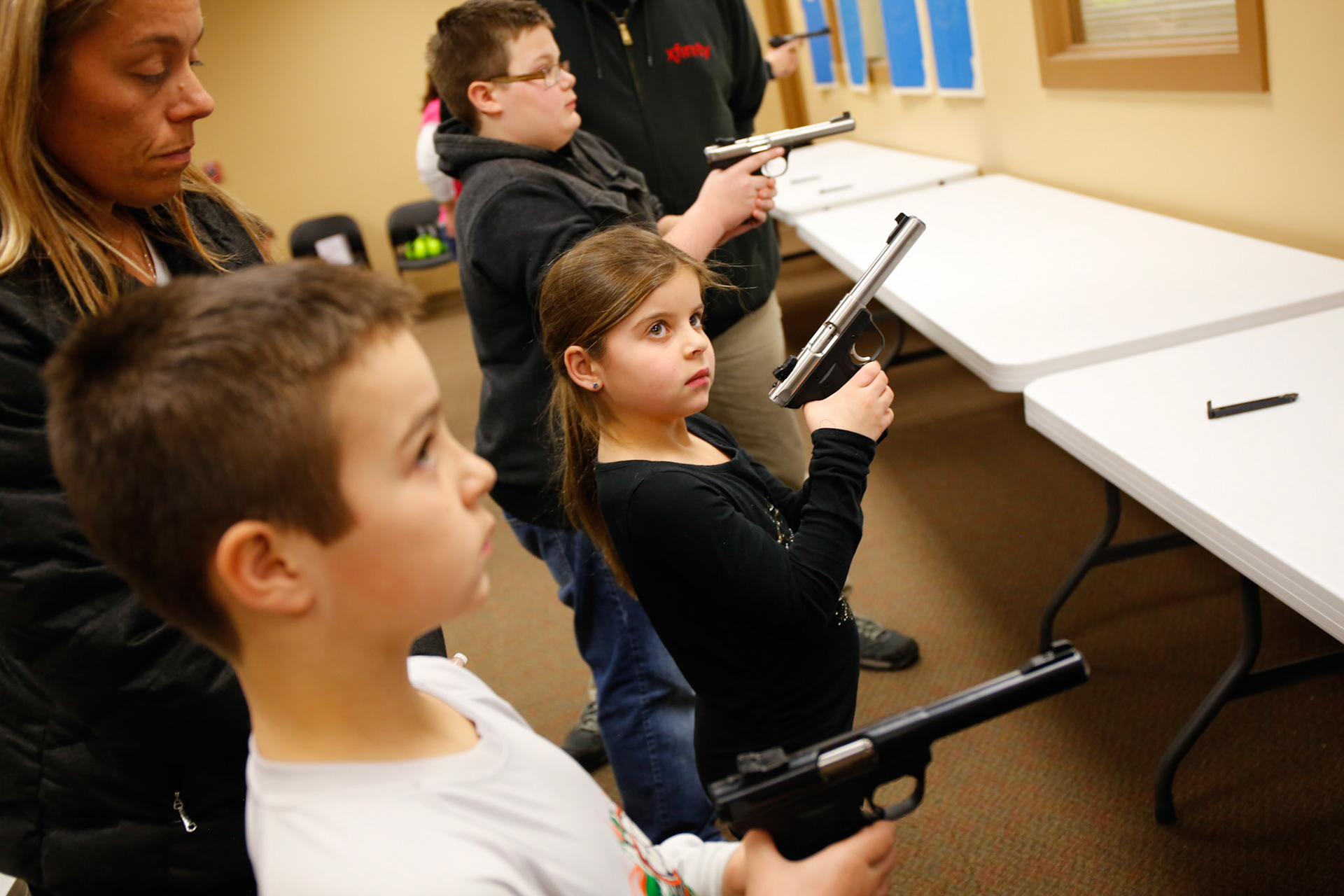 Students heft handguns during a safety class for youth ages 7-14 in suburban Chicago. (ChicagoTribune)