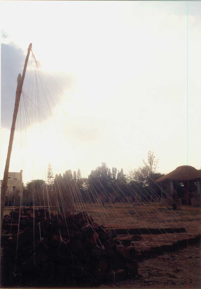 Azis T.M , size: 20ft x 15ft x 10ft (approx) , medium:  thread, bamboo poles, bricks, mud, pots and water. 