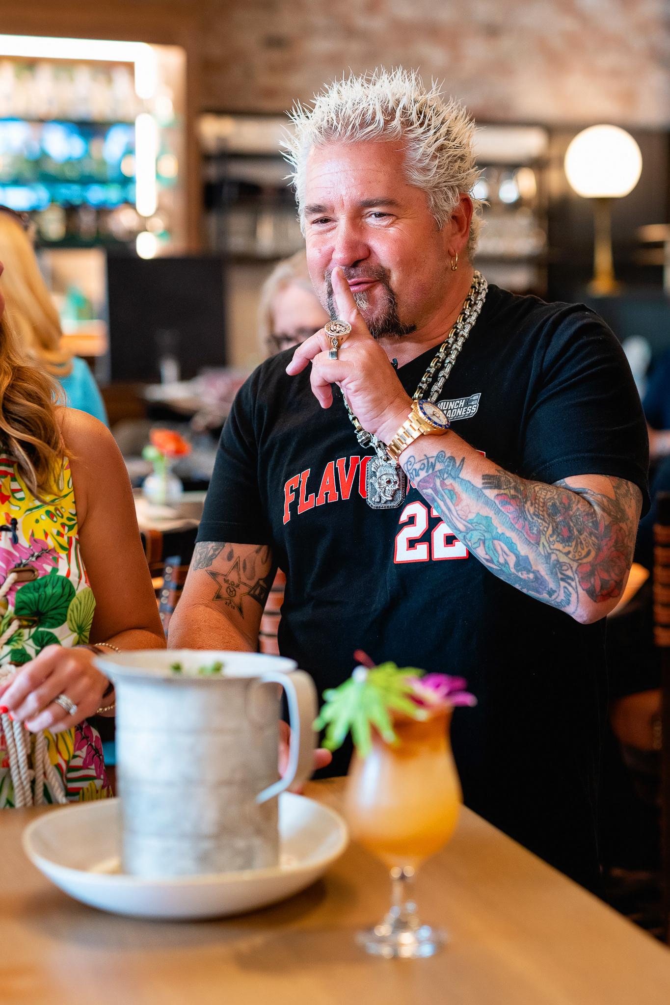 Guy Fieri showing off his newest Boston restaurant's menu to local tv reporters