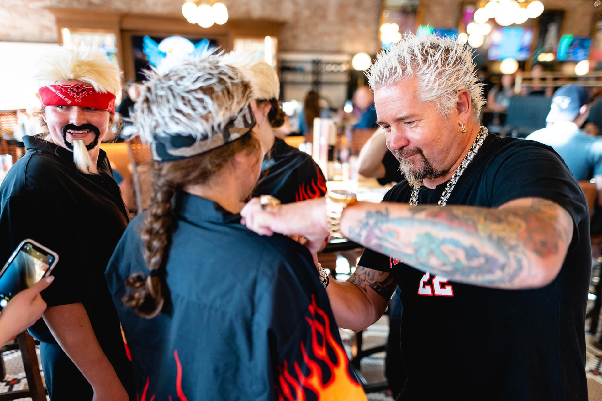 Guy Fieri signing shirts for fans who came dressed as him to his newest Boston restaurant location