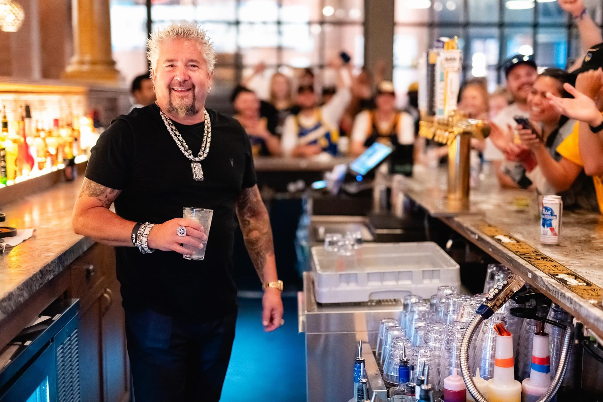 Guy Fieri behind the bar at one of his Boston restaurants entertaining fans