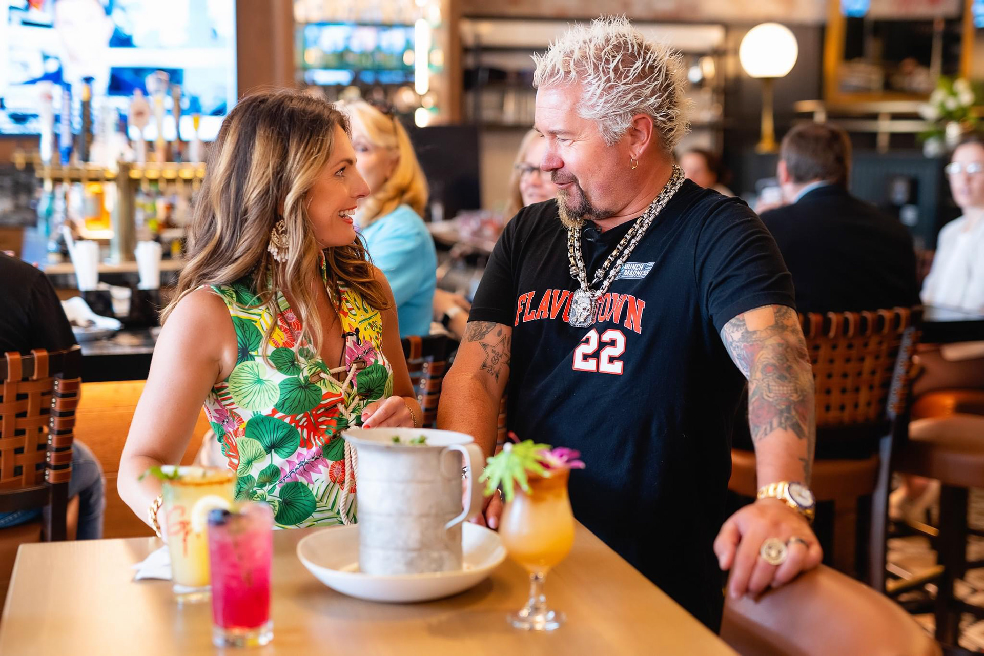 Guy Fieri showing off his newest Boston restaurant's menu to local tv reporters
