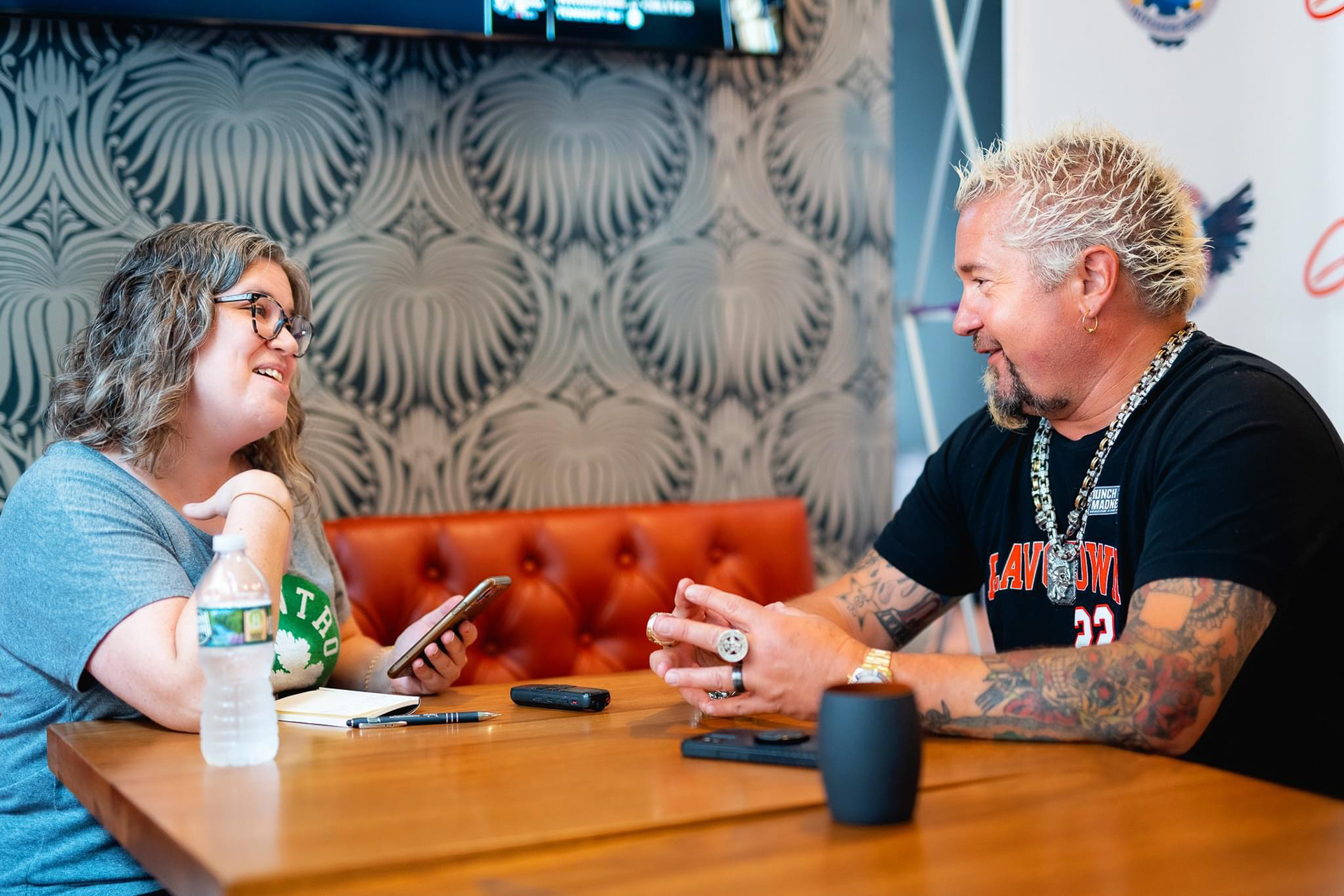 Guy Fieri speaking with a local Boston reporter in his newest Boston restaurant