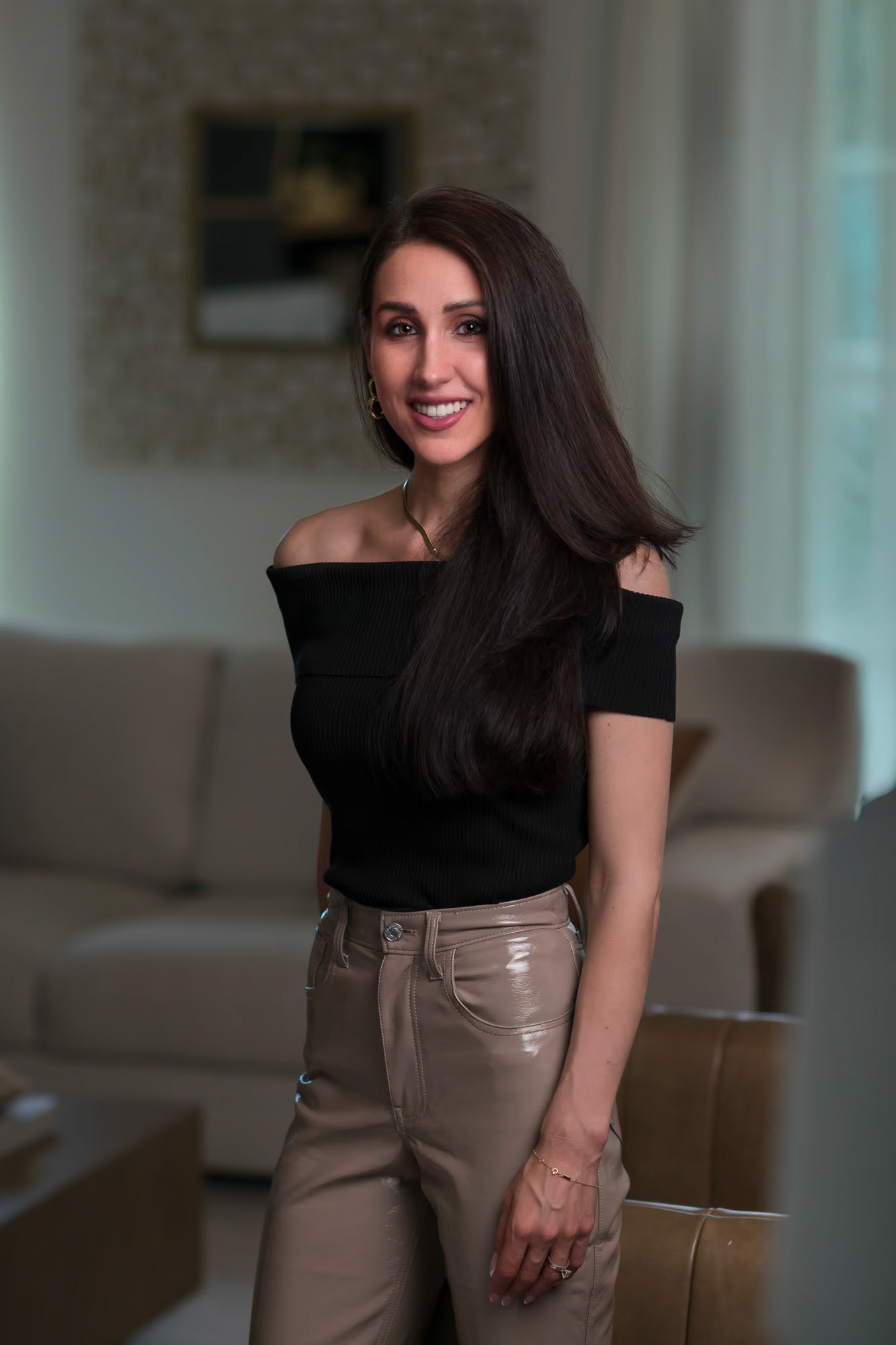 Photos of an internal designer in a living room standing in front of a sectional.