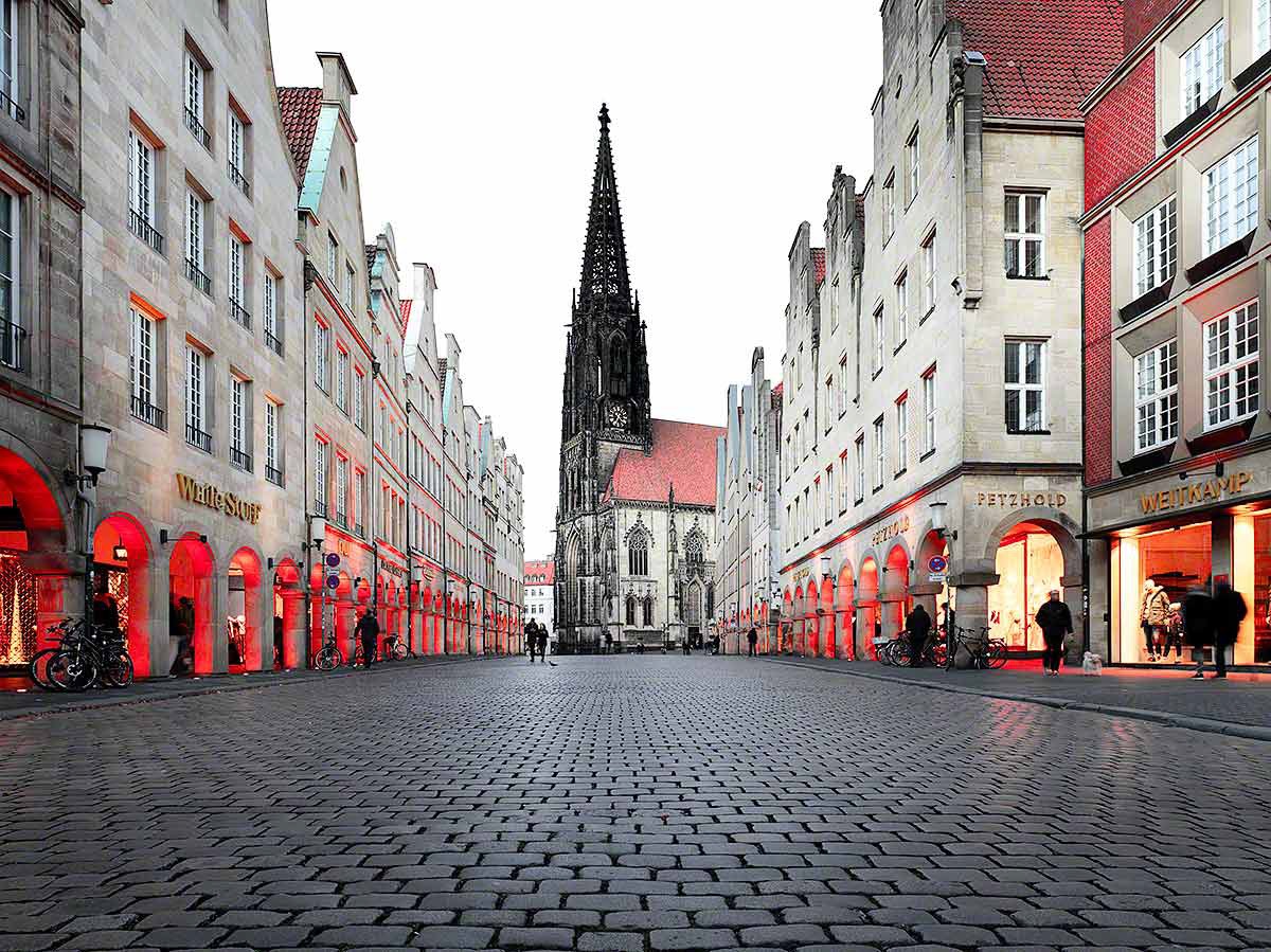 Der Prinzipalmarkt in Münsters Altstadt am Abend mit seinen Bogengängen in Kontrastrot stilisiert.