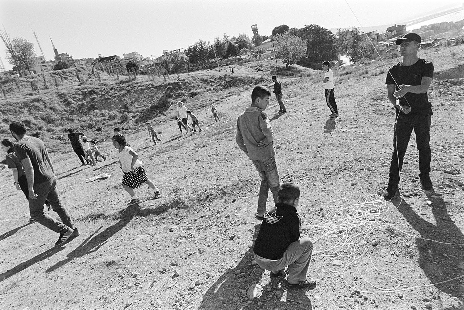 Children playing football and flying kites in an empty field in Kadifekale Neighborhood in İzmir.