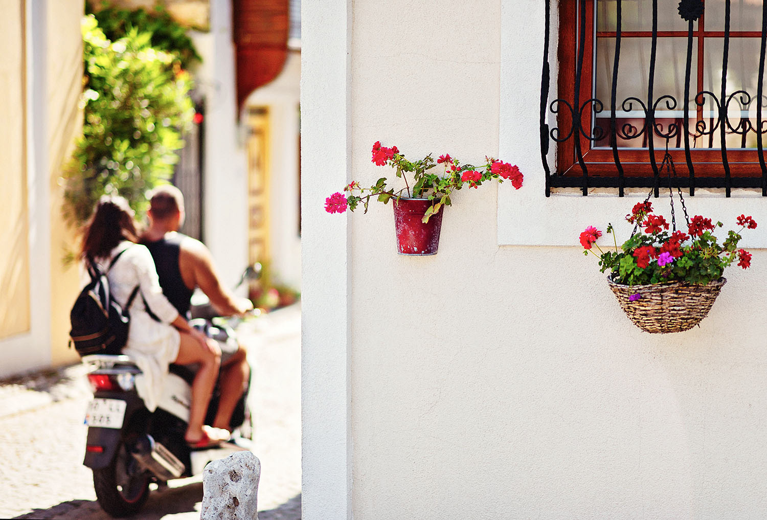 A couple riding on a motorcycle on the streets of Bozcaada.