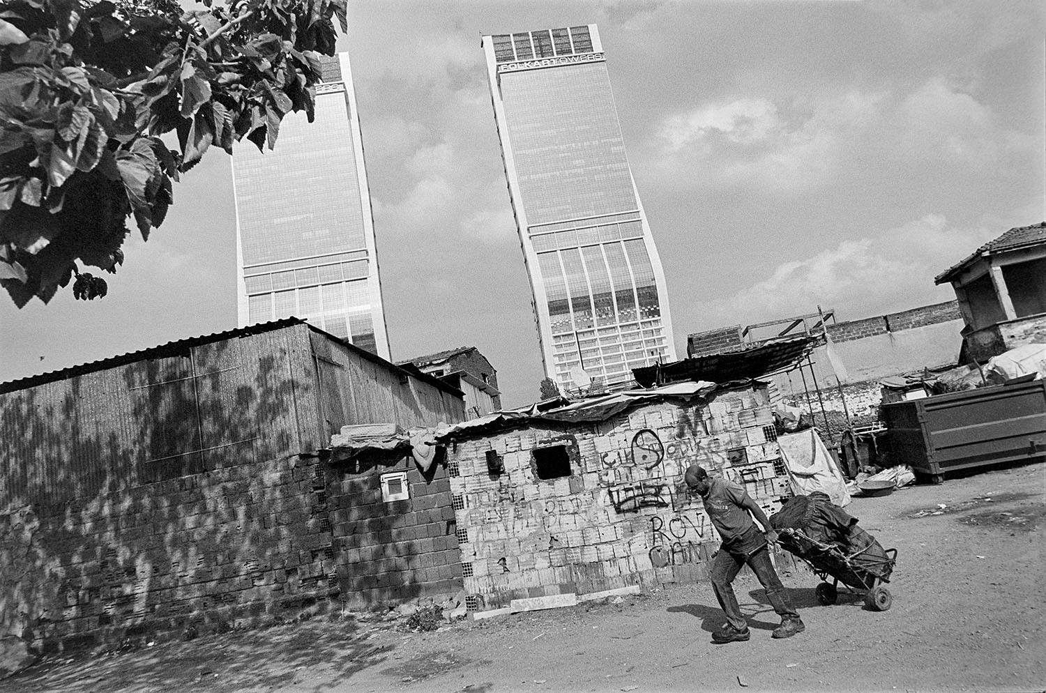 A Syrian refugee pulling a cart with Folkart Towers in the background in Bayraklı, İzmir.
