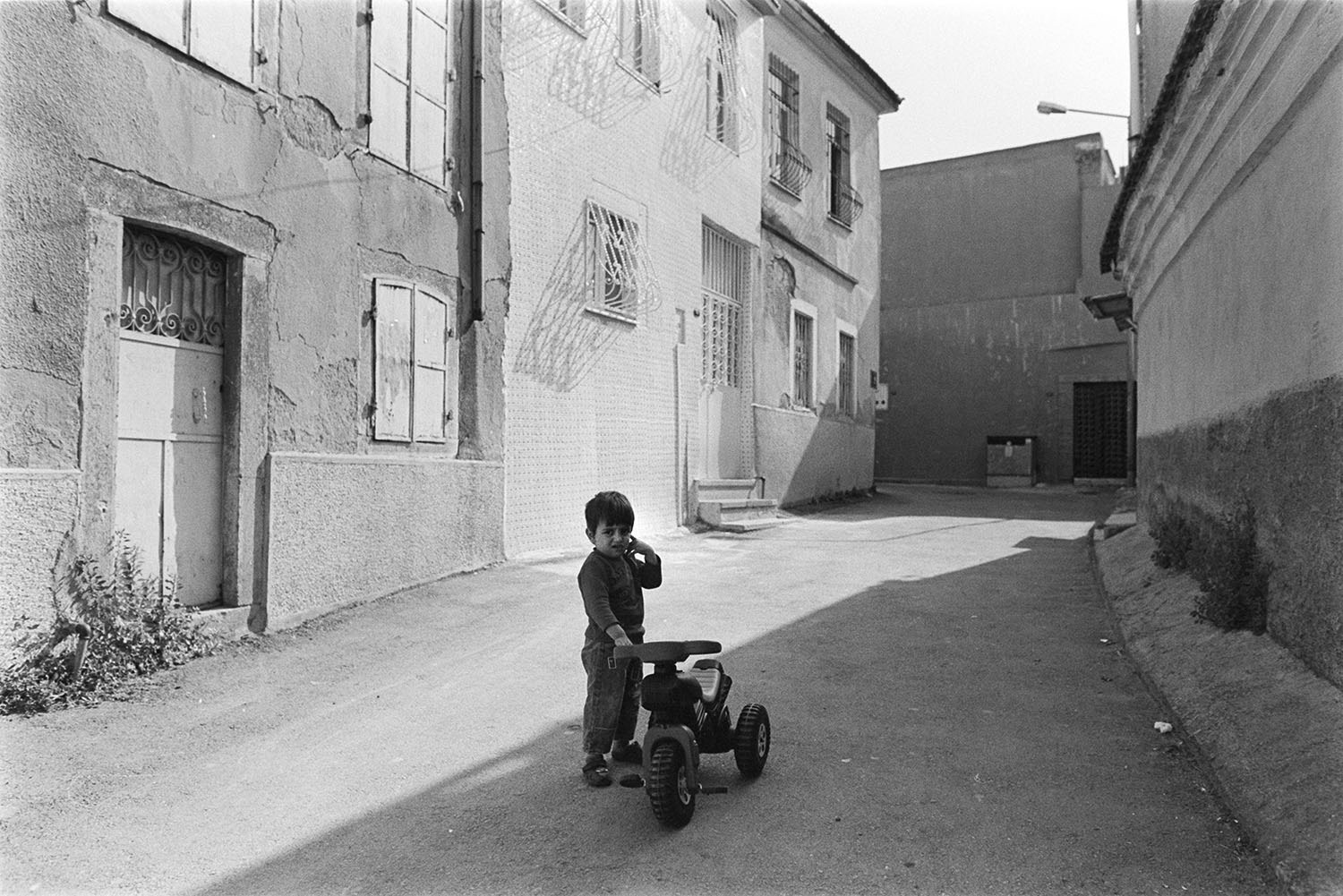 A child and his tricycle on the street in Konak.