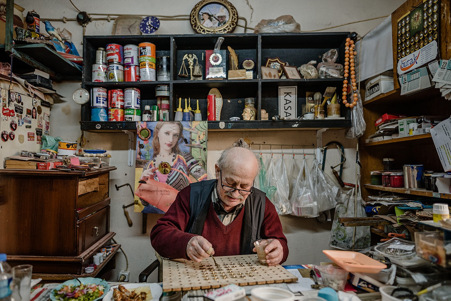 A lapel pin maker painting and decorating pins.