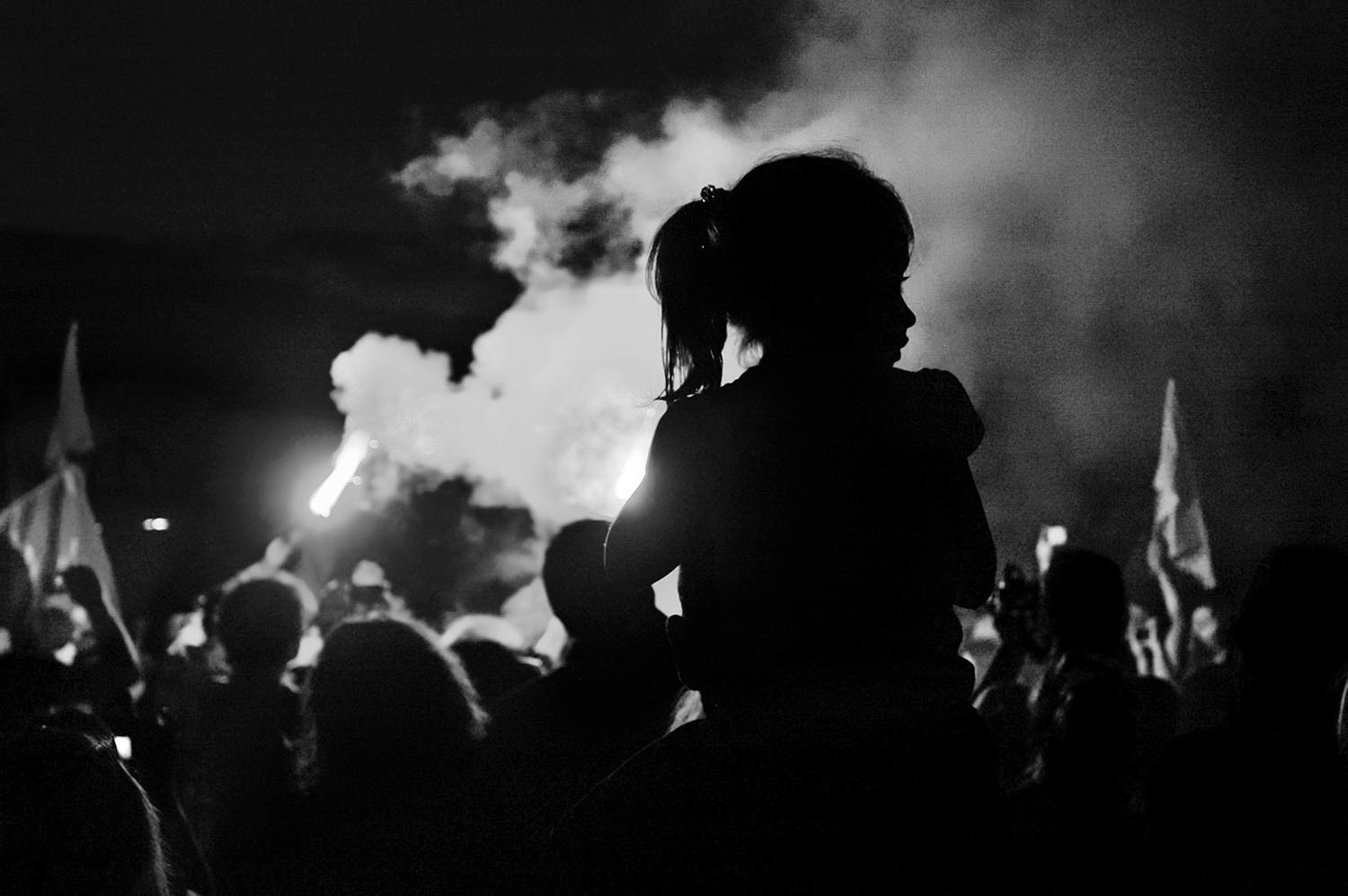 A child is seen on the shoulders of his father during the protests in Alsancak, İzmir at night time.