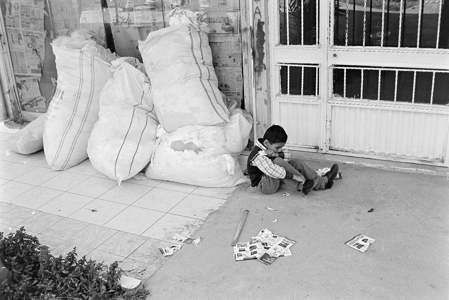 A child playing with cards on the streets of Şemikler District in Karşıyaka, İzmir, Türkiye.