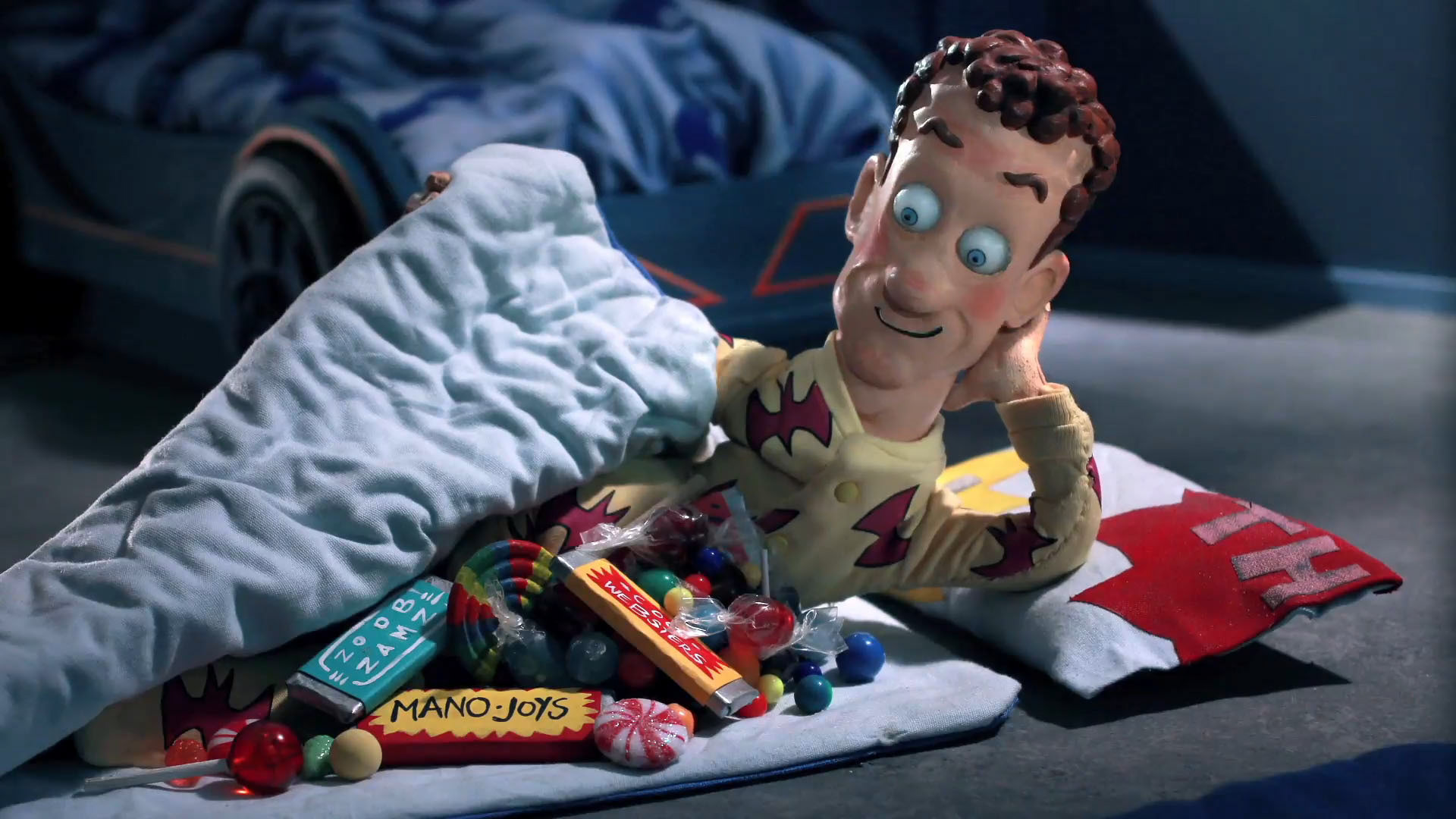 Screen still. Visible prop: candy pile. S1, E5 Sleepover.