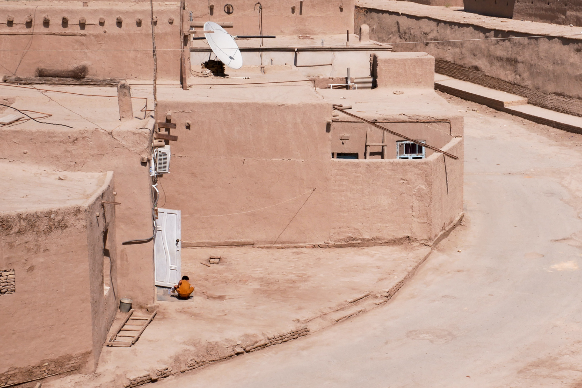 A boy playing in front of his house in Khiva