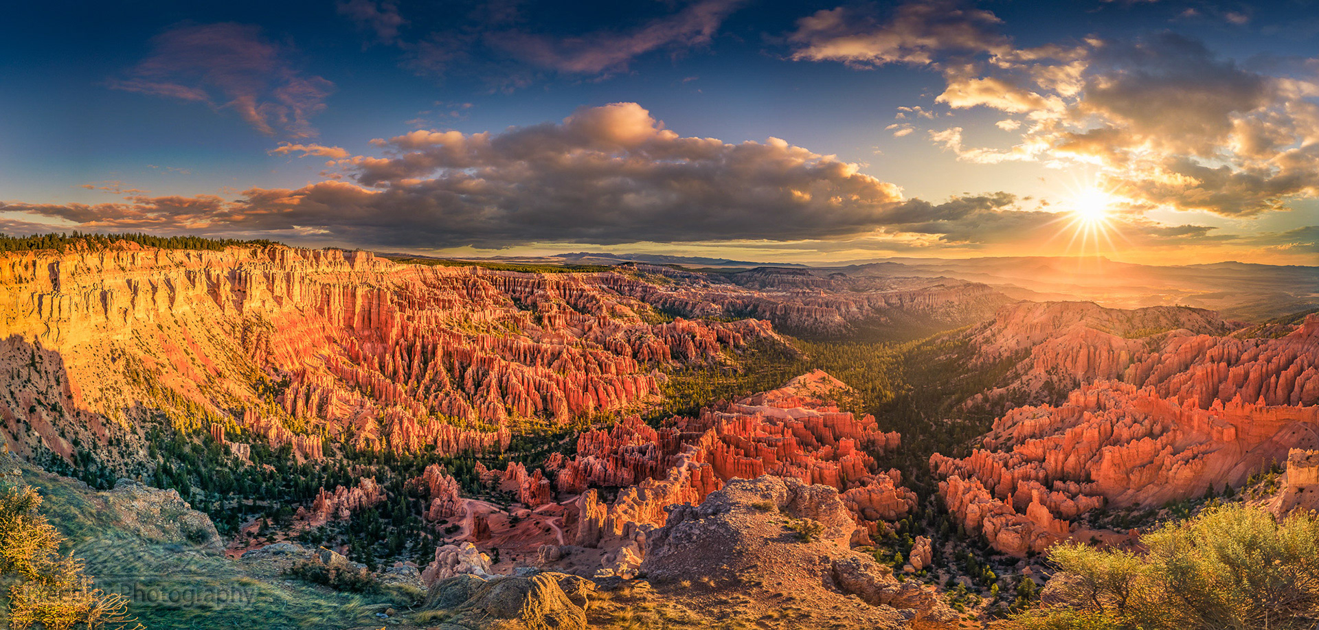 The panoramic view of Bryce Canyon at dawn with shining sun and colorful clouds