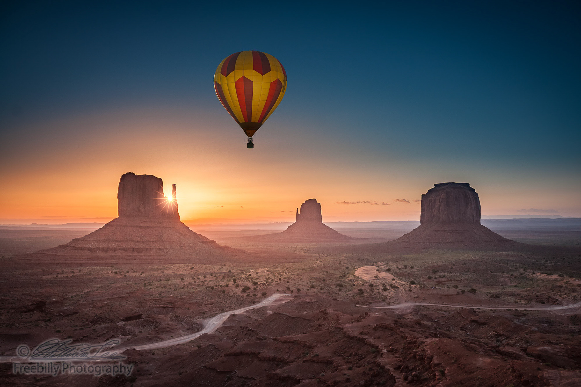 Single hot air balloon viewing sunrise at Monument Valley